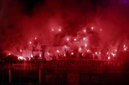 Benfica fans light up flares on the stands during the UEFA Champions League Round of 16 second leg football match between FC Barcelona and SL Benfica at the Estadi Olimpic Lluis Companys in Barcelona on March 11, 2025. (Photo by LLUIS GENE / AFP)