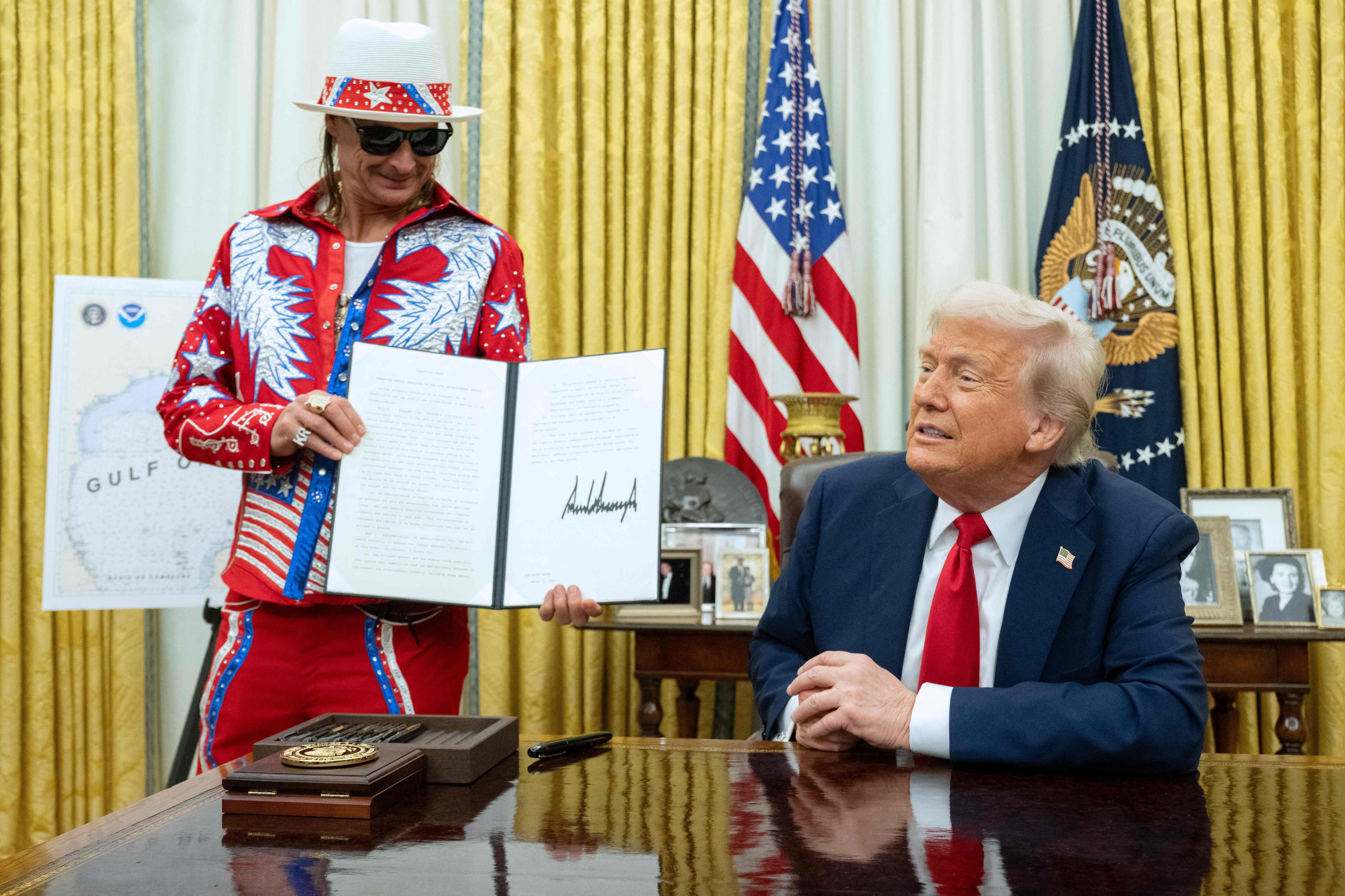 El cantante estadounidense Kid Rock sostiene una orden ejecutiva firmada por el presidente estadounidense Donald Trump en la Oficina Oval de la Casa Blanca (Foto Prensa Libre: AFP)