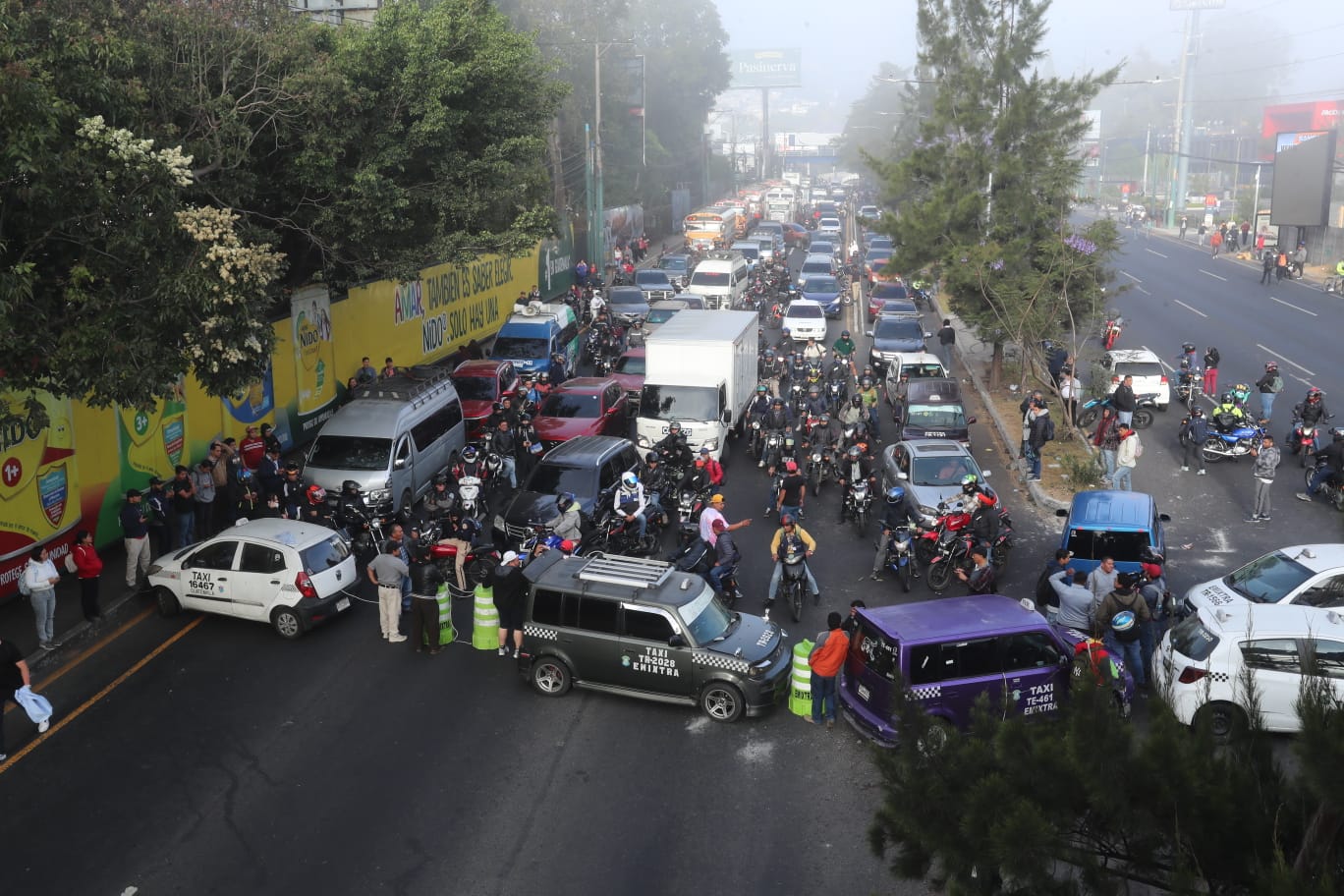 Automovilistas y peatones se vieron afectados por el bloqueo principal en la calzada Roosevelt. (Foto Prensa Libre: Juan Diego González)