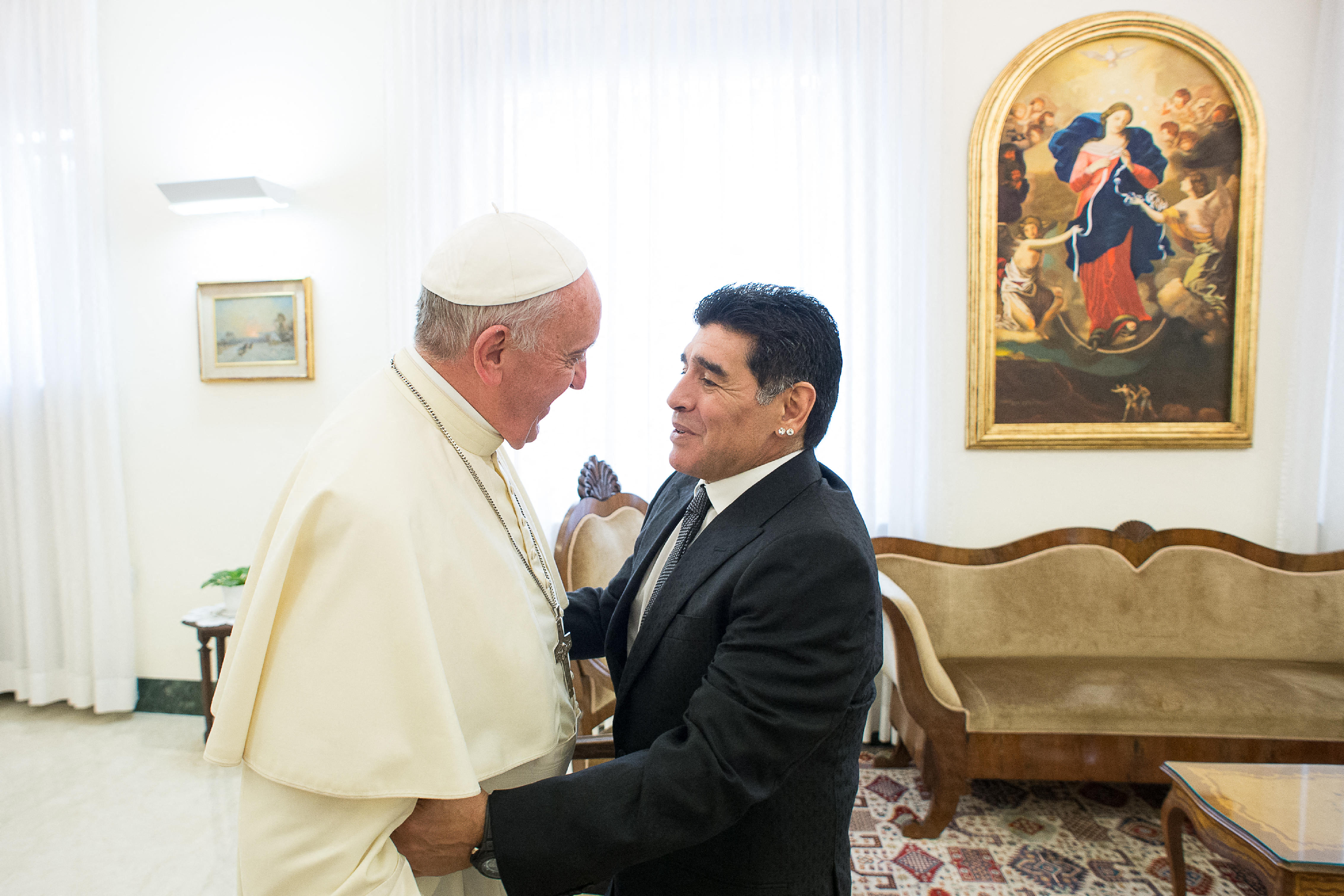 El papa Francisco saluda al exfutbolista argentino Diego Armando Maradona (der.) antes de una reunión con miembros de la organización Scholas Occurentes en el Vaticano el 4 de septiembre de 2014. (Foto Prensa Libre: AFP)