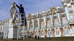 A museum worker removes winter protective cases from an authentic Venetian marble statue displayed in the Catherine's Park of the Tsarskoye Selo State Museum Preserve in Pushkin, outside Saint Petersburg, on April 7, 2025. (Photo by OLGA MALTSEVA / AFP)