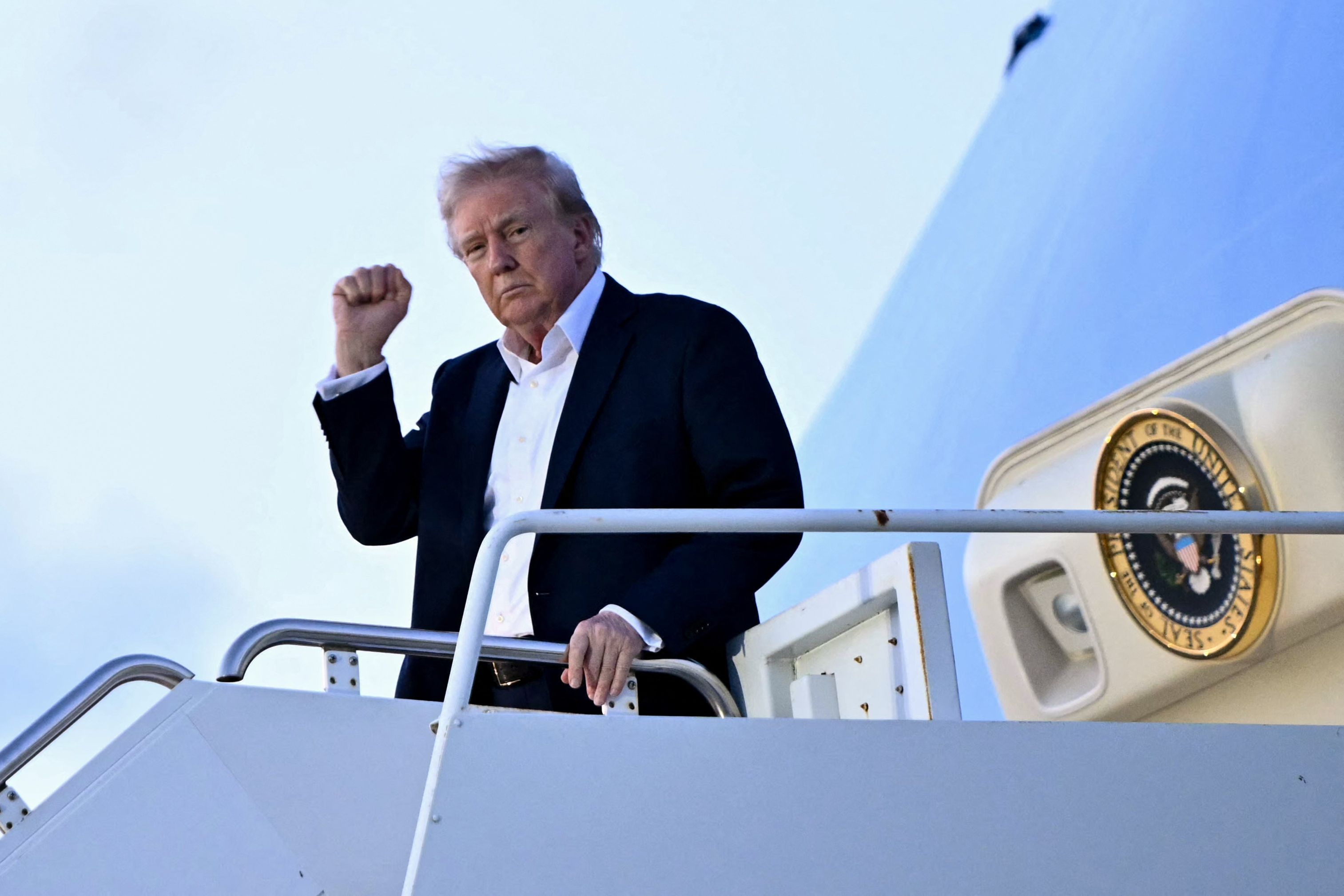 El presidente Donald Trump levanta el puño al descender del Air Force One en el Aeropuerto Internacional de Palm Beach, en West Palm Beach, Florida. (Foto Prensa Libre: AFP)