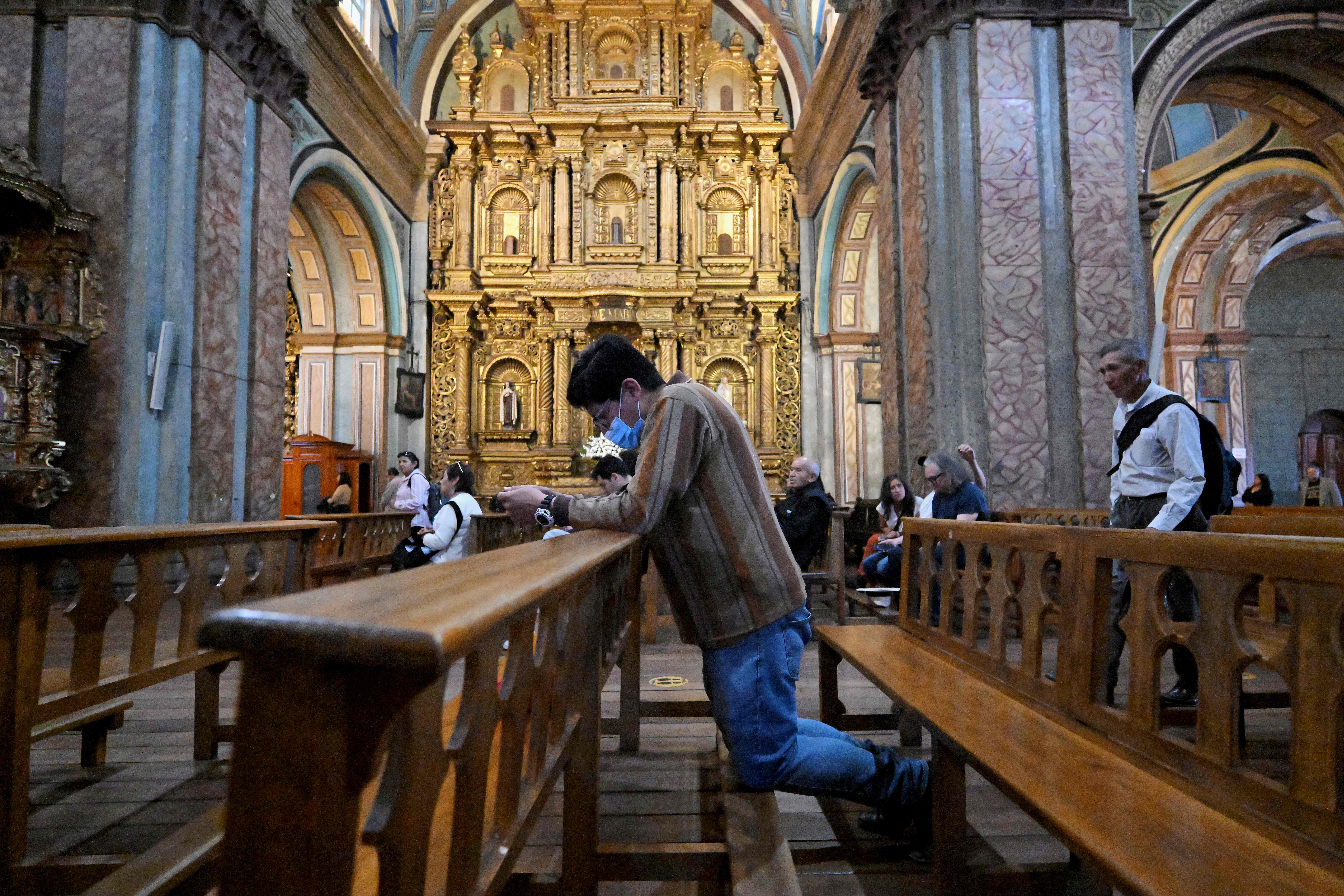 A faithful man prays during a mass for the late Pope Francis at the church of the Sagrario in Quito on April 21, 2025. Pope Francis died on April 21, 2025 aged 88, a day after making a much hoped-for appearance at Saint Peter's Square on Easter Sunday, the Vatican said in a statement. (Photo by Rodrigo BUENDIA / AFP)
