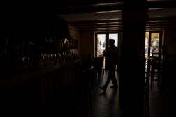 A barman works in a La Taberna restaurant without light in Ronda, near Malaga, on April 28, 2025, during a massive power cut affecting the entire Iberian peninsula and the south of France. Power went out across all of Spain and Portugal, cutting cellphone and internet networks, halting trains and trapping people in elevators, officials said. The operator, Red Electrica, said it would likely take six to 10 hours to restore power in the country and urged people not to speculate as to the cause of the outage. (Photo by JORGE GUERRERO / AFP)