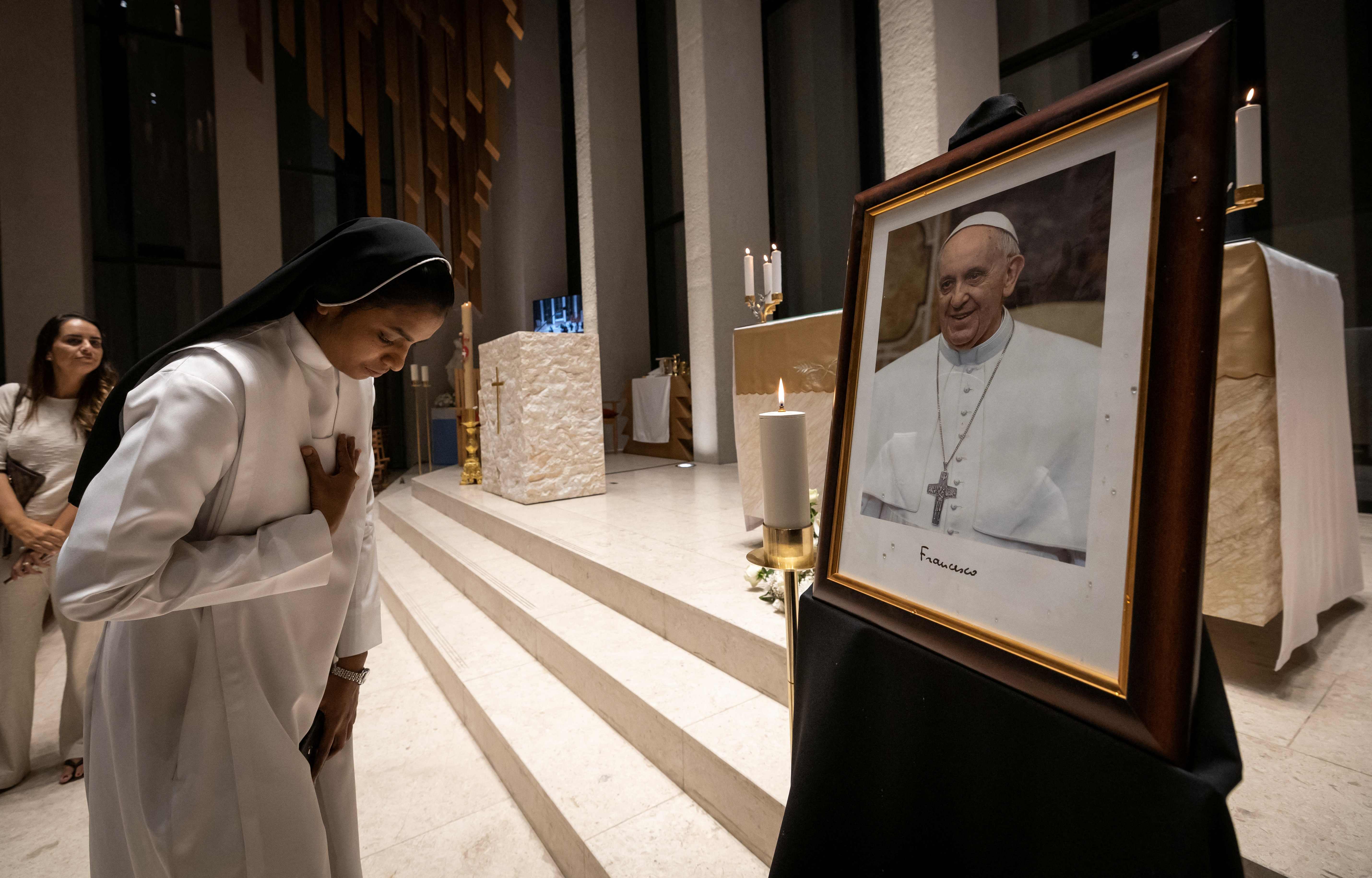 Una monja muestra sus respetos ante un retrato del papa Francisco durante una misa realizada en memoria del Sumo Pontífice. (Foto Prensa Libre: AFP)