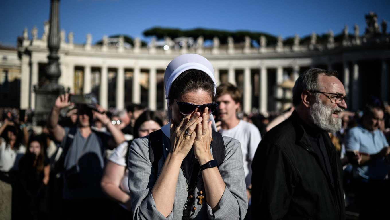 TOPSHOT - A nun reacts as white smoke (unseen) signals that cardinals elected a new pope during their conclave in the Vatican on May 8, 2025. Thick black smoke billowed on May 8, 2025, from the chimney of the Sistine Chapel in a sign that cardinals again failed to elect a new head of the Catholic Church. (Photo by JEFF PACHOUD / AFP)