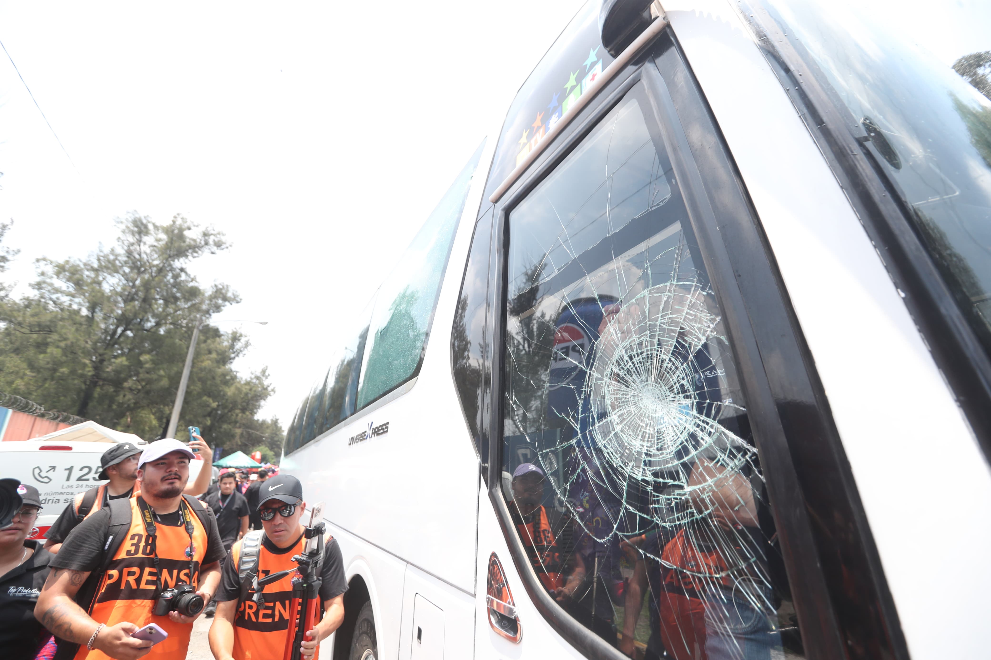 Periodistas observan los daños que sufrió el bus que transportaba a Antigua GFC, a su llegada al estadio del Trébol (Foto Prensa Libre: Byron Rivera).'