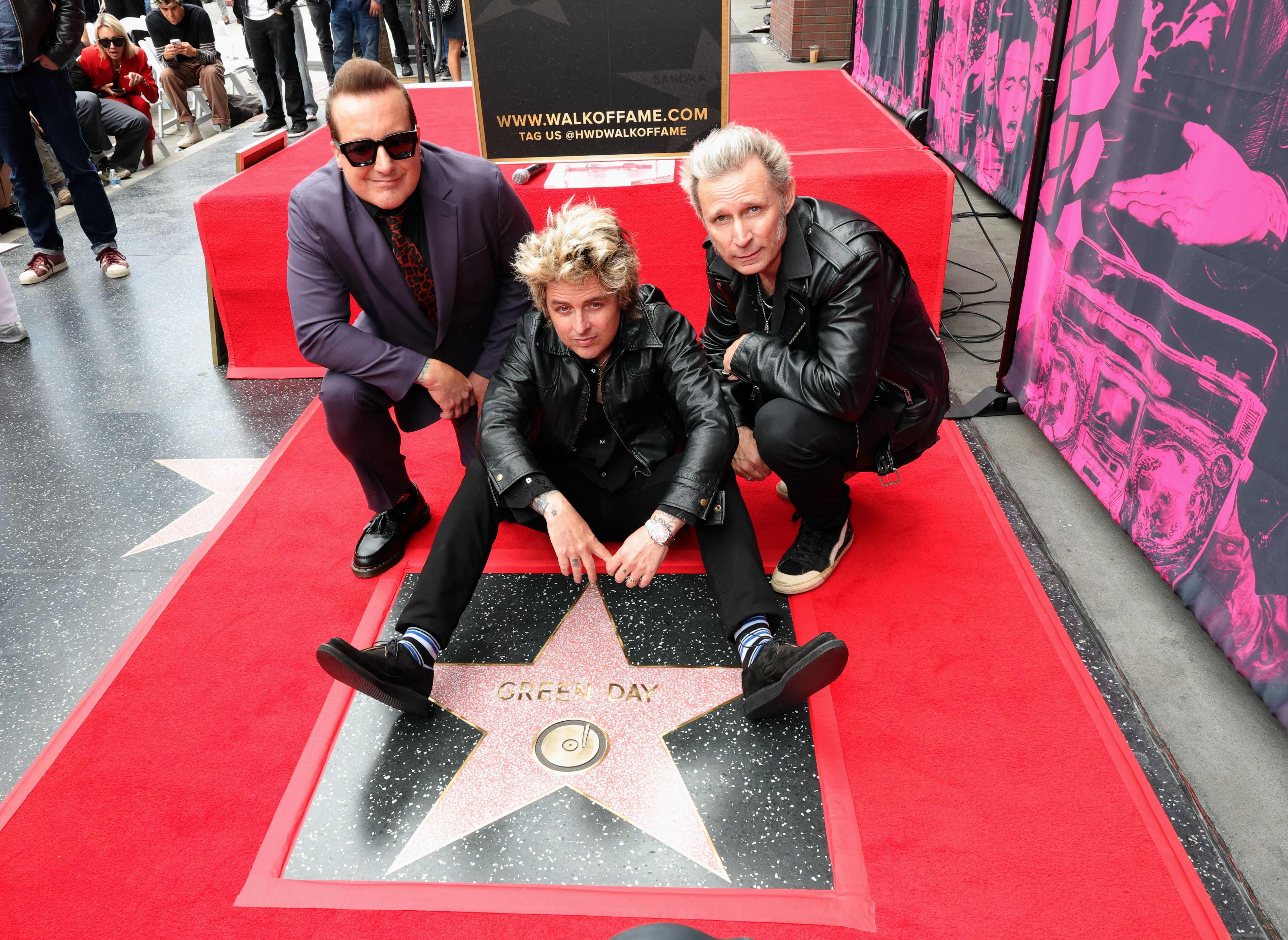 HOLLYWOOD, CALIFORNIA - MAY 01: (L-R) Tré Cool, Billie Joe Armstrong and Mike Dirnt of Green Day pose with their star during their Hollywood Walk of Fame Star Ceremony on May 01, 2025 in Hollywood, California.   Monica Schipper/Getty Images/AFP (Photo by Monica Schipper / GETTY IMAGES NORTH AMERICA / Getty Images via AFP)