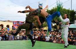 Guatemalan wrestlers Dangerus Jr. (R) and Guerrero Jaguar, from "Arena Renacer Maya," fight in San Juan Sacatepequez, Guatemala, on June 22, 2025, during the anniversary of a local radio station. (Photo by JOHAN ORDONEZ / AFP)