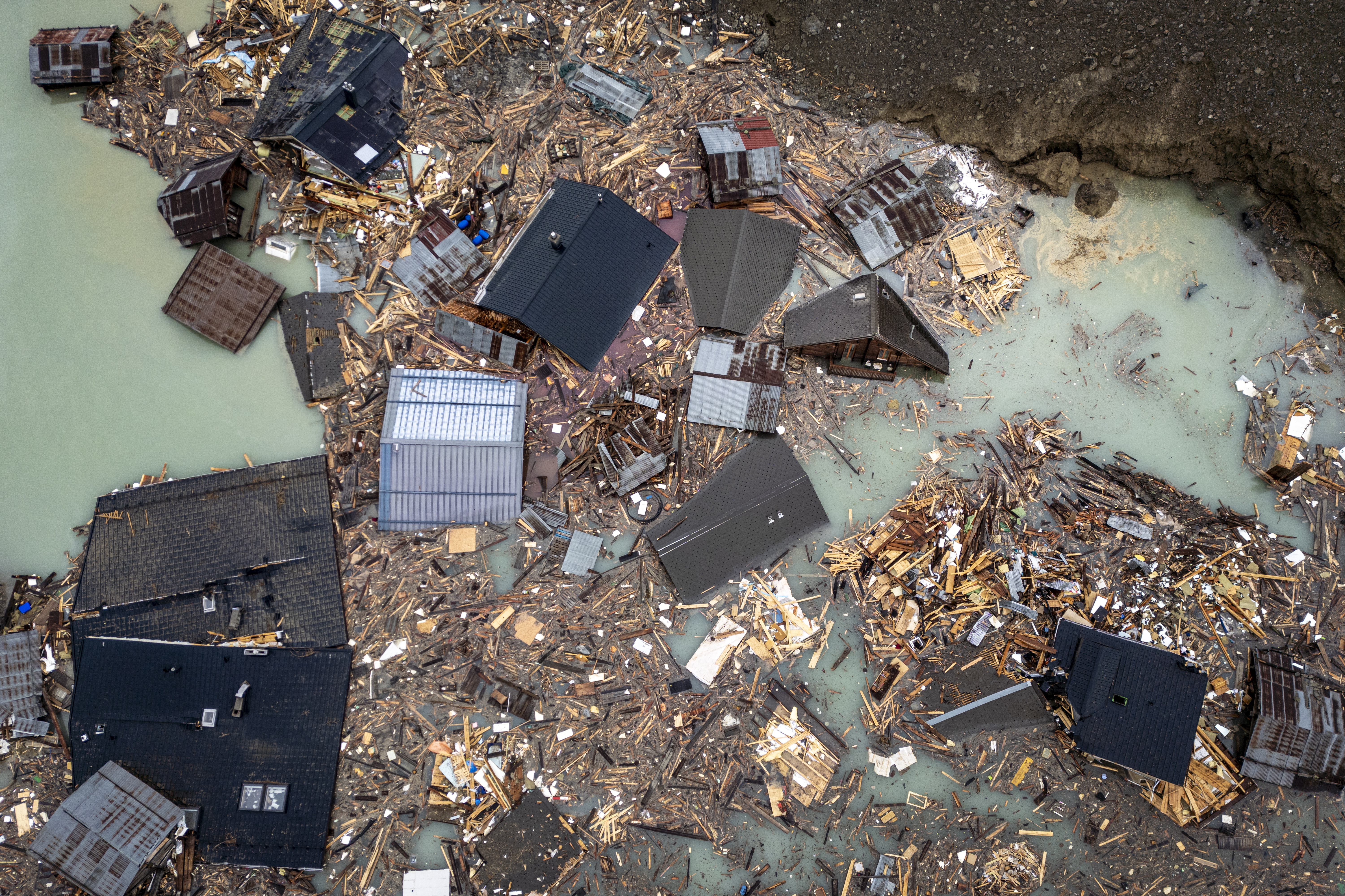 Blatten (Switzerland), 06/06/2025.- An aerial view shows destroyed houses in the water from the river Lonza that formed a lake beside a massive avalanche triggered by the collapse of the Birch Glacier, which swept down to the valley floor and destroyed the village of Blatten, Switzerland, 06 June 2025. A large part of the village of Blatten, located in the Loetschental Valley in the canton of Valais, was buried under masses of ice, mud, and rock. Between 19 and 28 May, several million cubic meters of rock fell from the Kleines Nesthorn mountain above Blatten, creating a nine-million-tonne debris cone on the Birch Glacier, which ultimately collapsed on 28 May 2025. One person remains missing. (Avalancha, deslizamiento de tierras, Suiza) EFE/EPA/MICHAEL BUHOLZER IMAGE TAKEN WITH A DRONE