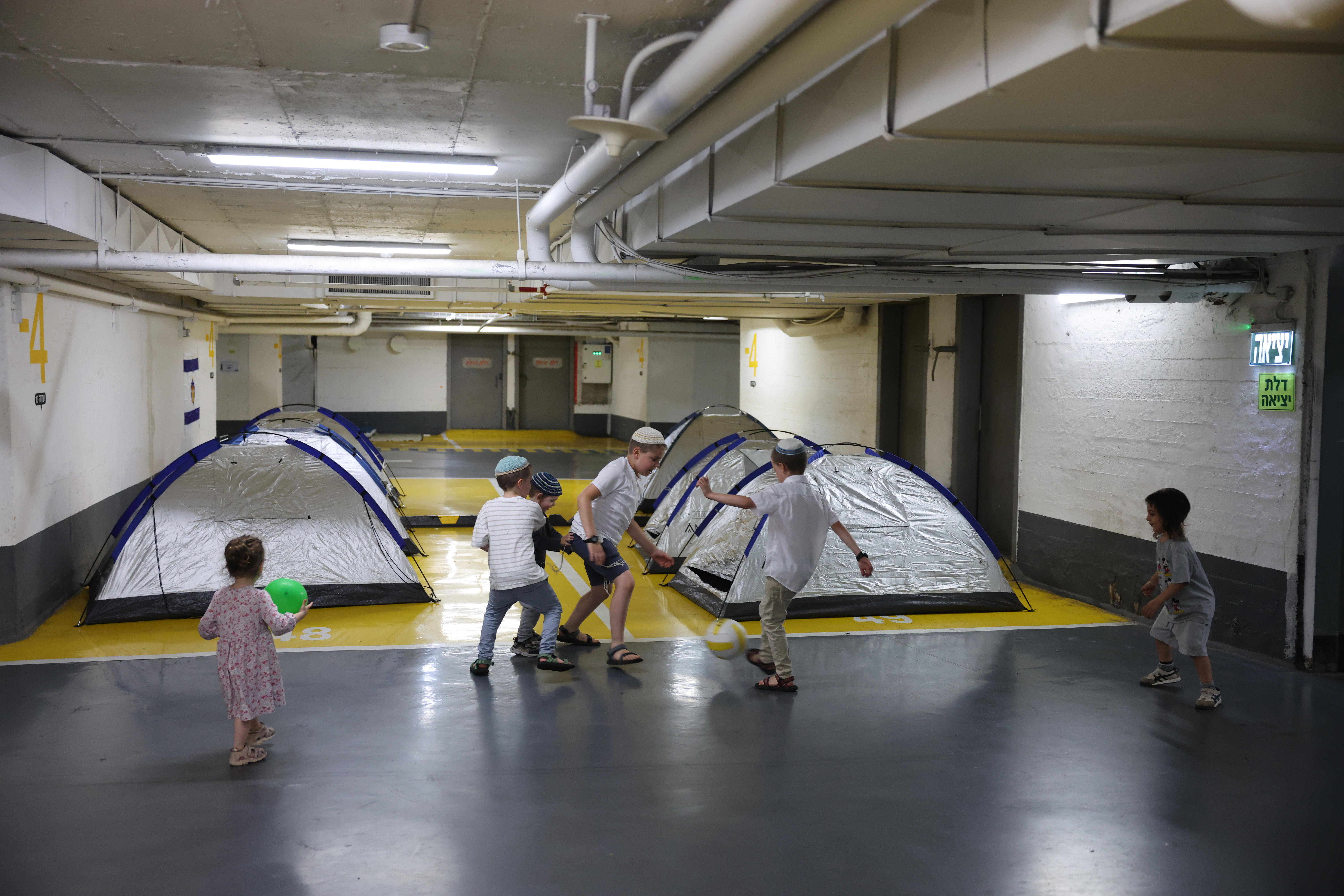 Niños juegan futbol en un bunker de seguridad en Tel Aviv por los ataques con misiles de Irán. (Foto Prensa Libre: EFE) 