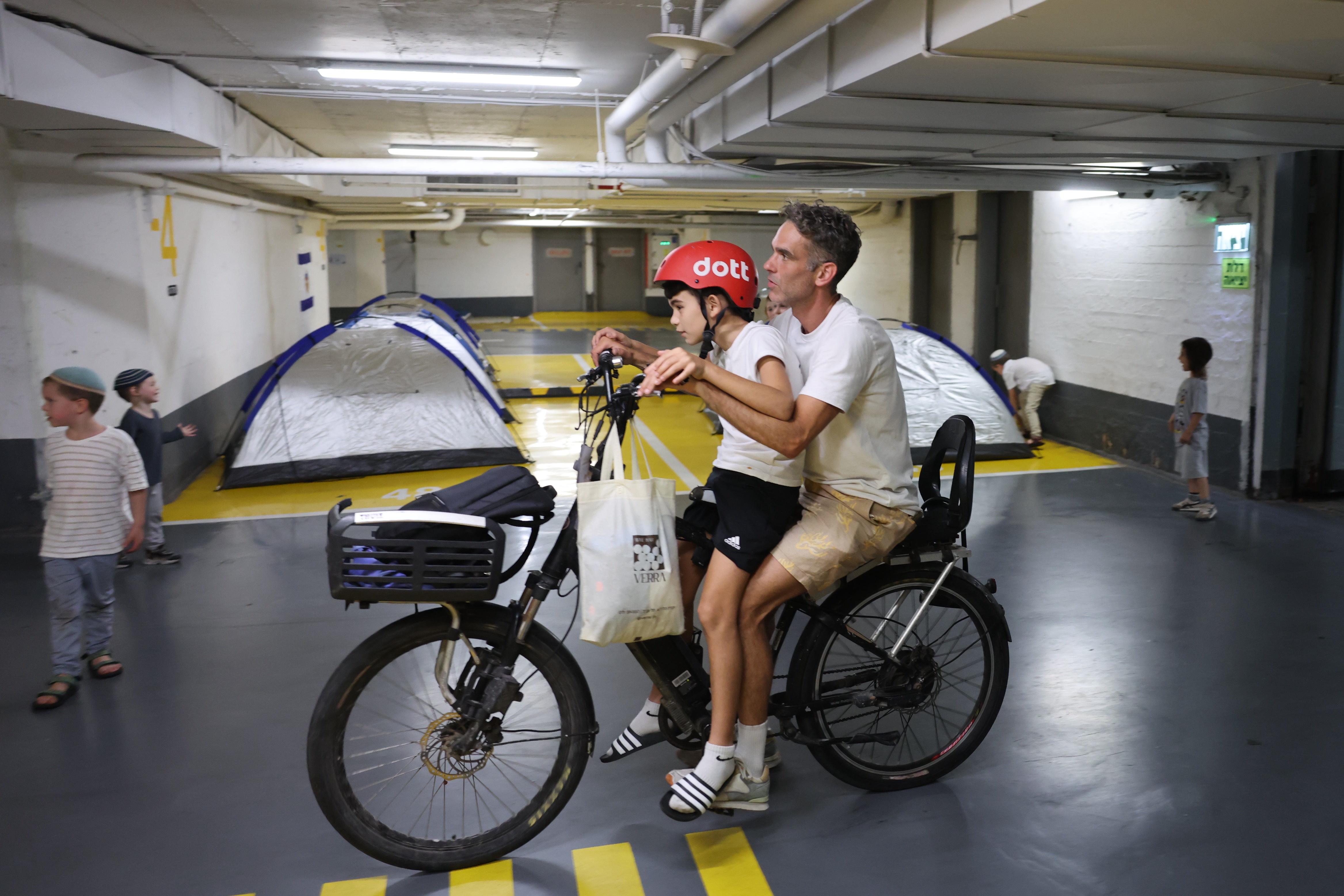 Un padre da un paseo a su hijo en el bunker de seguridad en Tel Aviv Israel. (Foto Prensa Libre: EFE) 