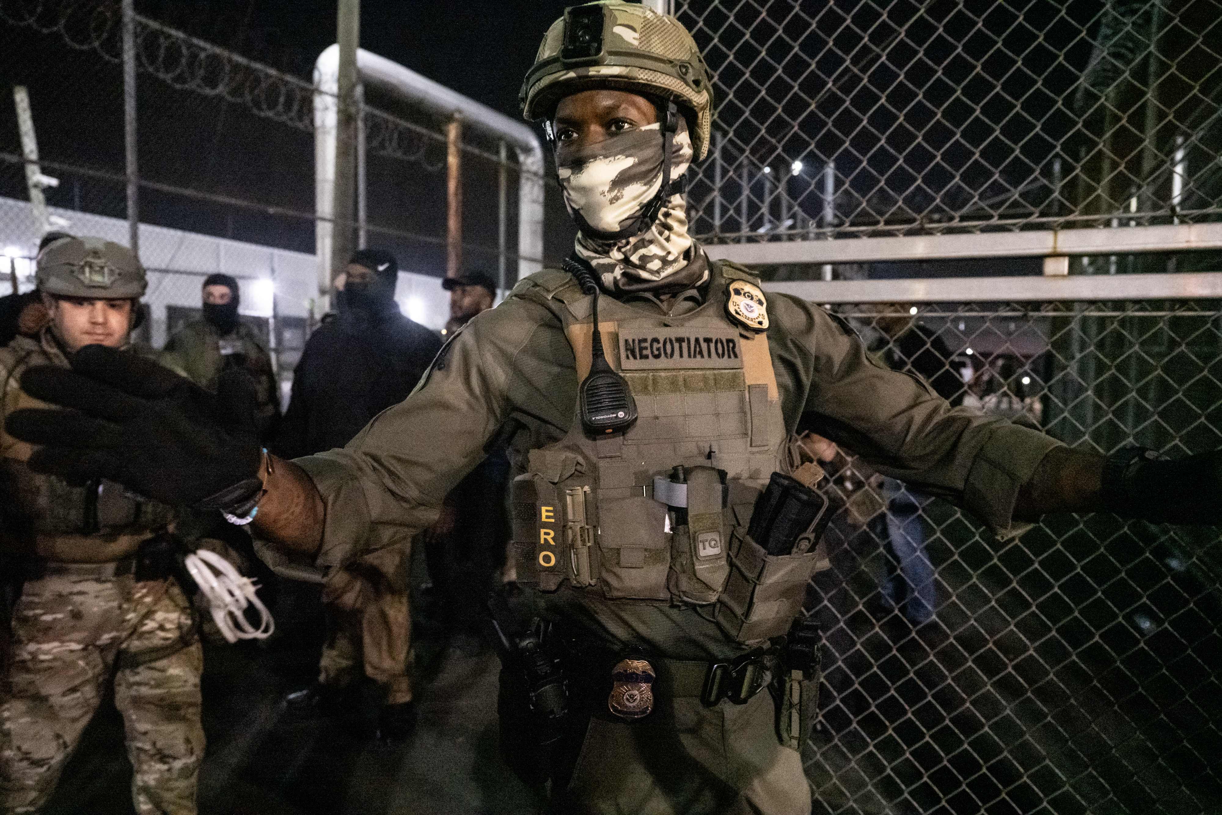 NEWARK, NEW JERSEY - JUNE 12: U.S. Immigration and Customs Enforcement (ICE) agents guard outside Delaney Hall, a migrant detention facility, while anti-ICE activists demonstrate on June 12, 2025 in Newark, New Jersey. Anti-ICE protests have been spreading to cities across America since Ice deportation quotas have increased.   Stephanie Keith/Getty Images/AFP (Photo by STEPHANIE KEITH / GETTY IMAGES NORTH AMERICA / Getty Images via AFP)