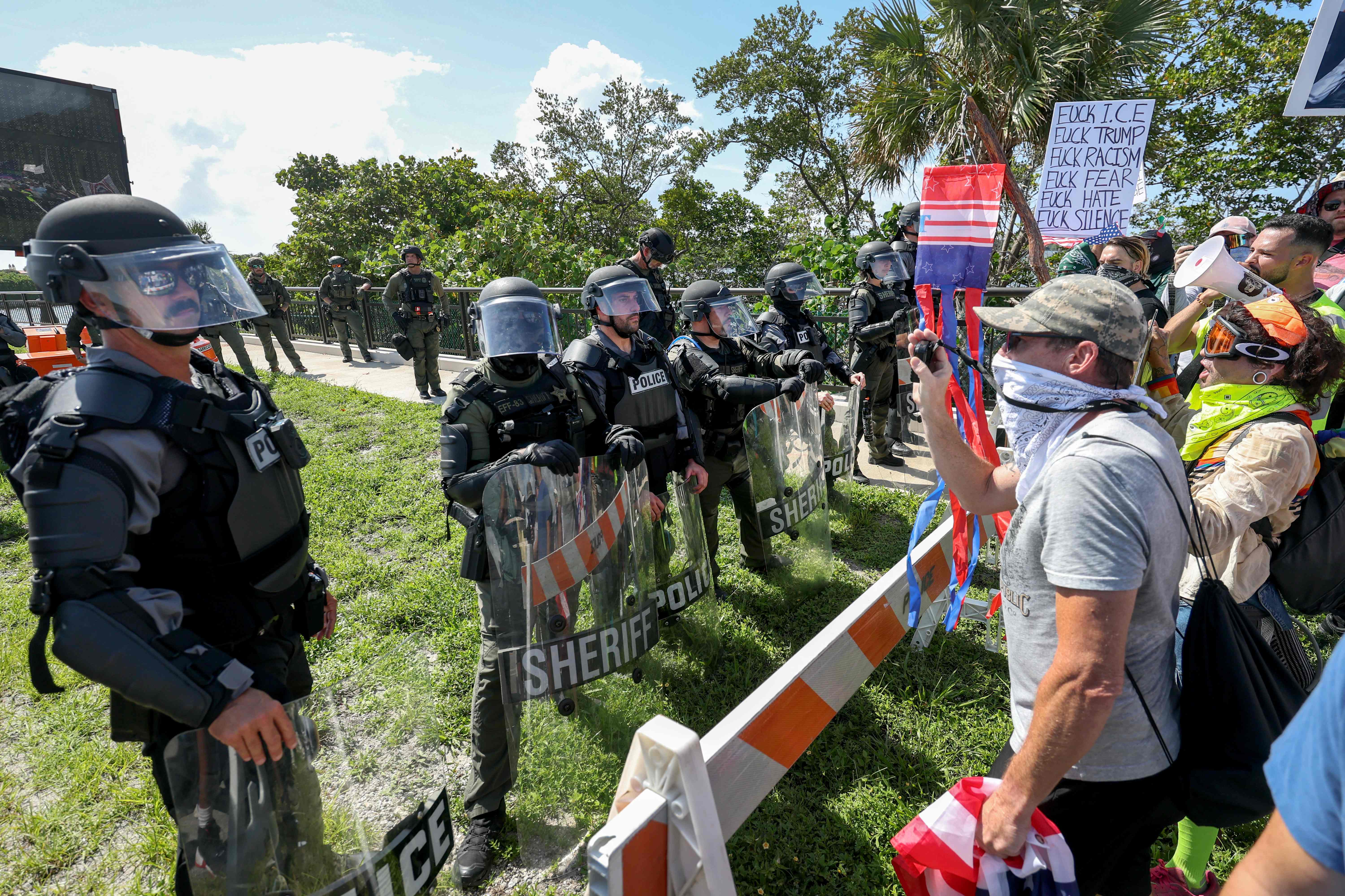 Agentes del sheriff de Palm Beach impiden que los manifestantes crucen un puente hacia la casa del presidente Donald Trump en Mar-a-Lago, durante la protesta "No Kings Day". (Foto Prensa Libre: AFP)