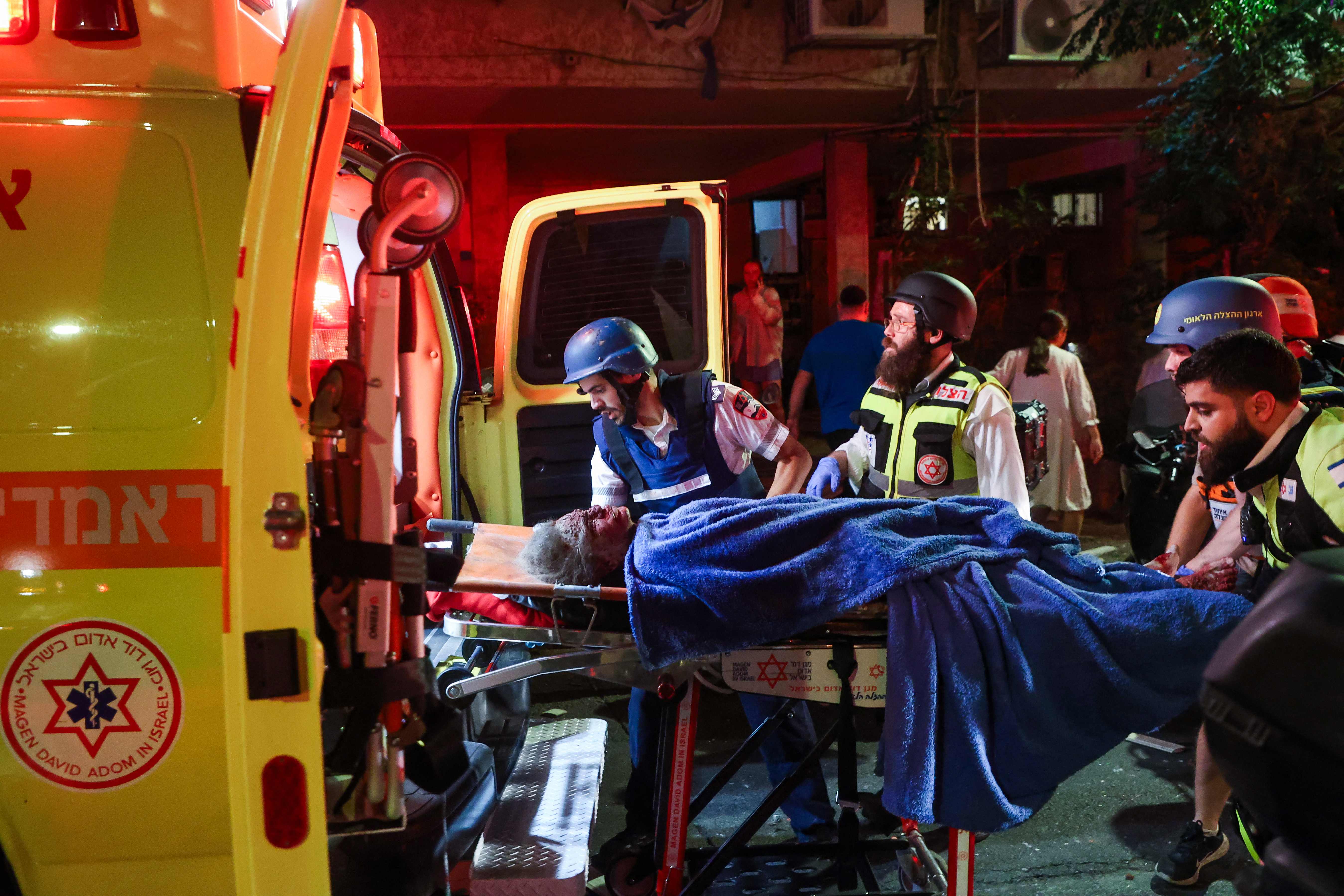 Los equipos de emergencia israelíes evacuan a un residente herido de un lugar alcanzado por un misil lanzado desde Irán. (Foto Prensa Libre: AFP)