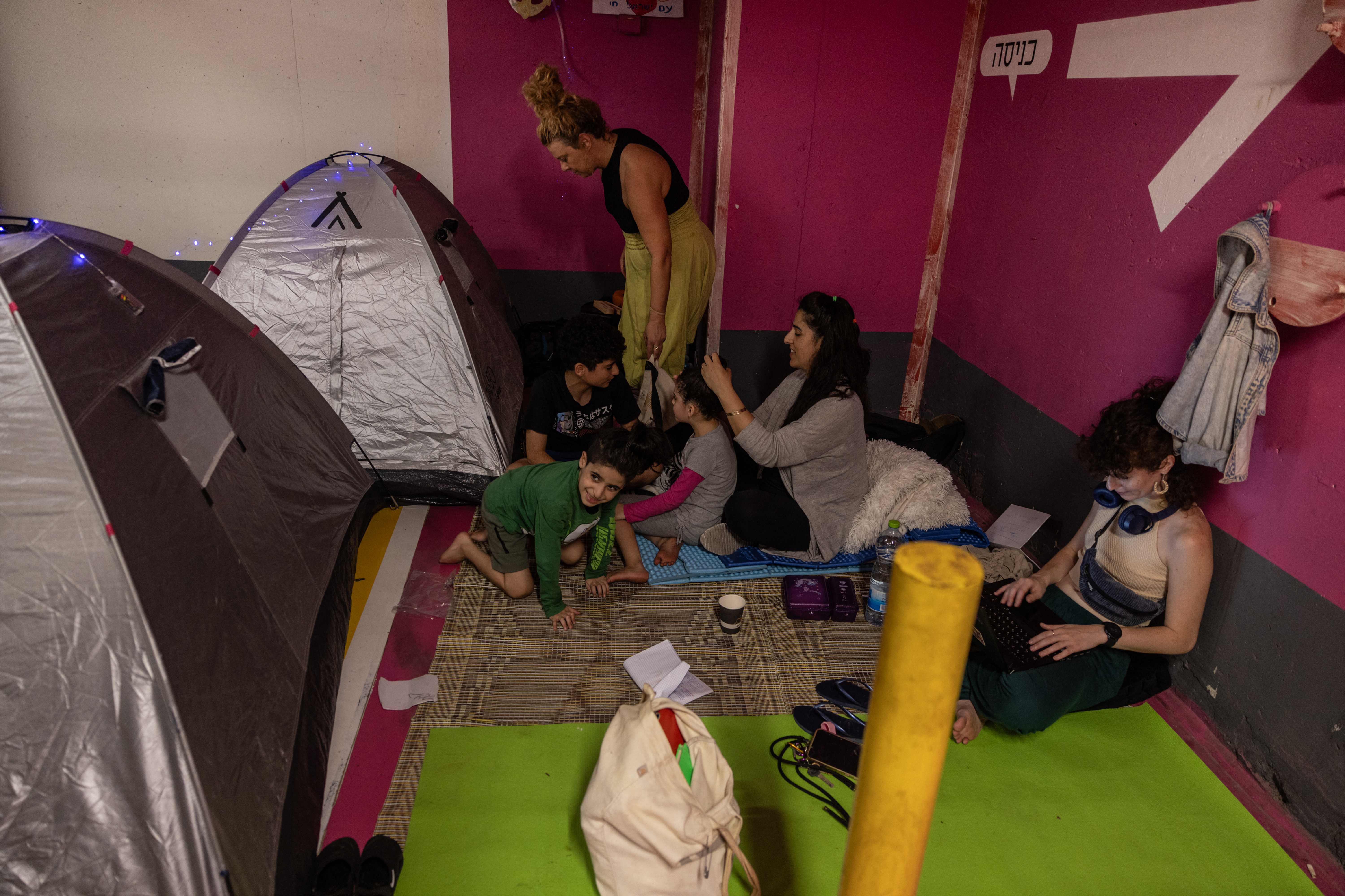 Personas se refugian en tiendas de acampar en el sótano de un centro comercial, debido al ataque de Irán sobre Israel. (Foto Prensa Libre: AFP) 