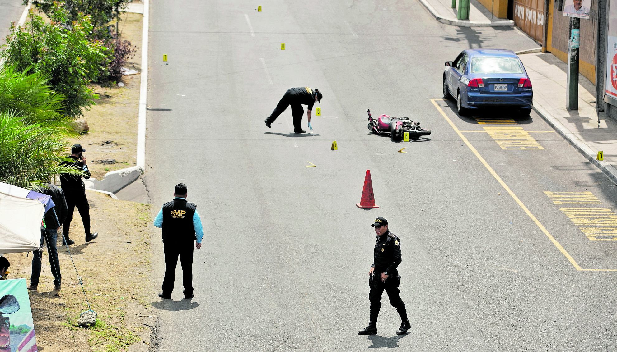 VAPULEADOS NARANJO TAXISTAS. En una jornada violenta, en Mixco en el Bulevar El Naranjo, dos supuestos extorsionistas balean a un taxista para luego ser vapuleados por otros taxistas. Al final del día, tanto el taxista como los extorsionistas vapuleados fallecen en centros asistenciales. El taxista fue identificado como Fardy Mayén Pérez mientras que los sicarios como Roger Ronald Gómez y Edwin Herrera. En la imagen, peritos del Ministerio Público recaban evidencias.