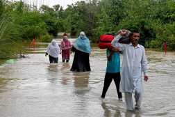 Villagers wade through floodwaters after heavy rainfall at Kasur district in Punjab province on August 31, 2025. Nearly half a million people have been displaced by flooding in eastern Pakistan after days of heavy rain swelled rivers, relief officials said on August 30, as they carried out a massive rescue operation. (Photo by Arif ALI / AFP)