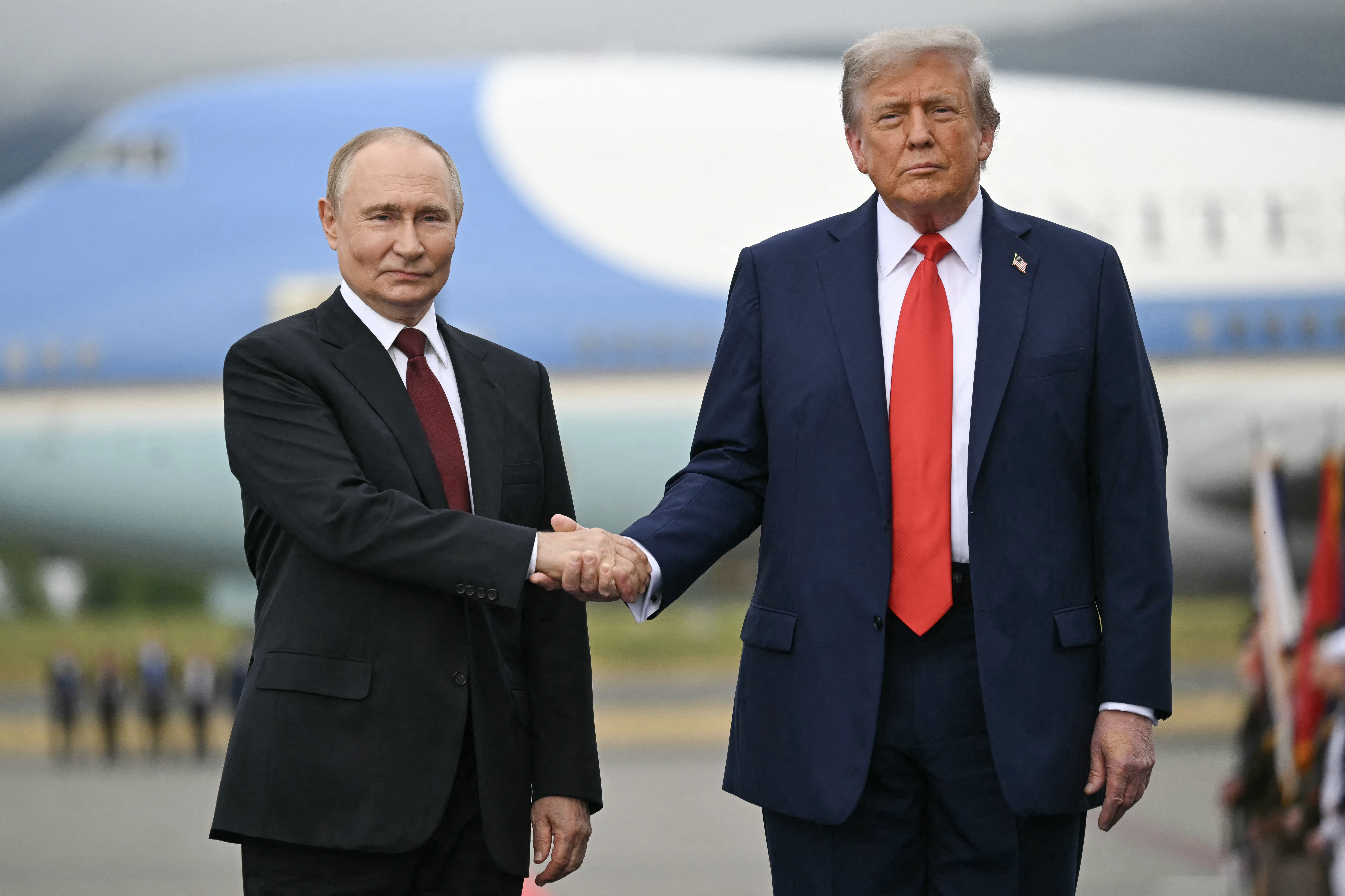 US President Donald Trump greets Russian President Vladimir Putin on the tarmac after they arrived at Joint Base Elmendorf-Richardson in Anchorage, Alaska, on August 15, 2025. Putin is in Alaska at the invitation of Trump in his first visit to a Western country since he ordered the 2022 invasion of Ukraine that has killed tens of thousands of people. (Photo by ANDREW CABALLERO-REYNOLDS / AFP)