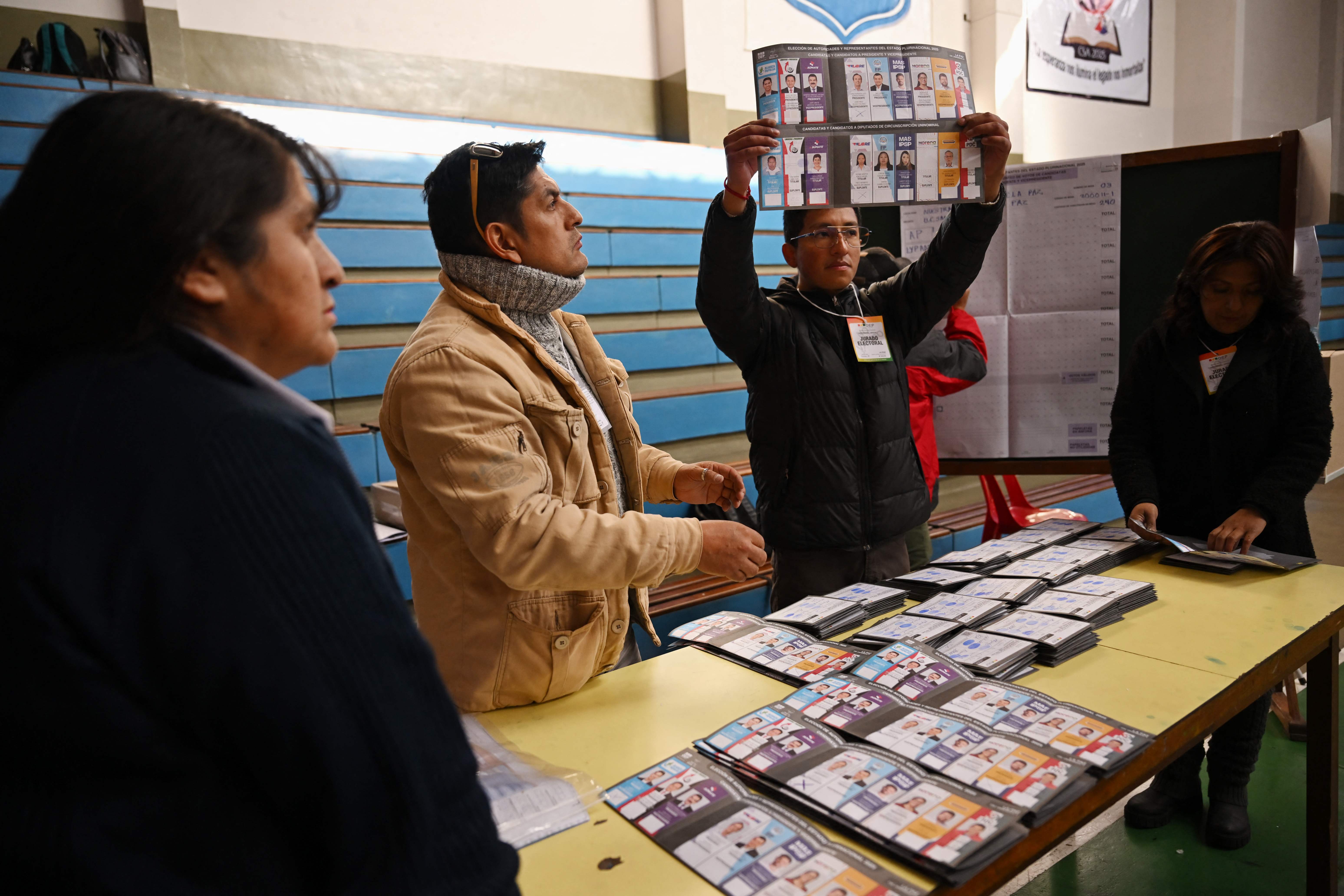 Election staffers count votes after the closing of a polling station during the presidential election in La Paz on August 17, 2025. Bolivians head to the polls Sunday for elections marked by a deep economic crisis that has seen the left implode and the right eyeing its first shot at power in 20 years. (Photo by MARTIN BERNETTI / AFP)