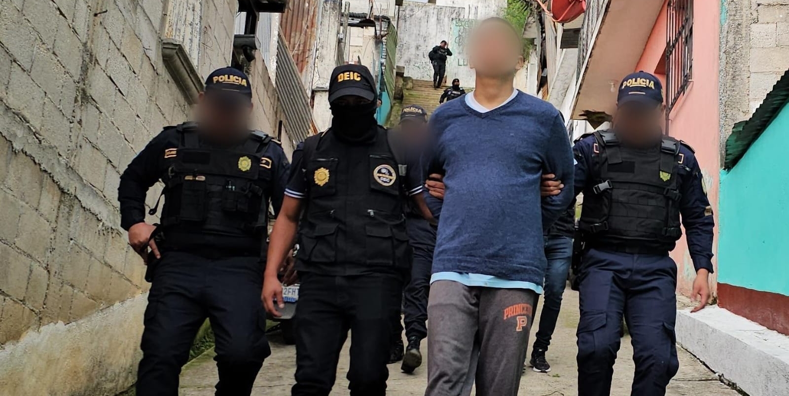 Agentes de la PNC trasladan a uno de los detenidos señalados de integrar una estructura de extorsión. (Foto Prensa Libre: PNC)