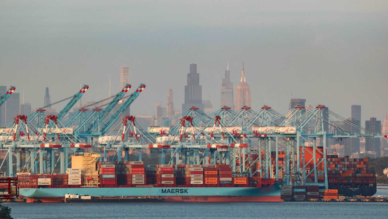 Cargo ships and shipping containers are seen at the Port Jersey Container Terminal, with the Manhattan skyline in the distance, in Jersey City, New Jersey on September 22, 2025. (Photo by CHARLY TRIBALLEAU / AFP)