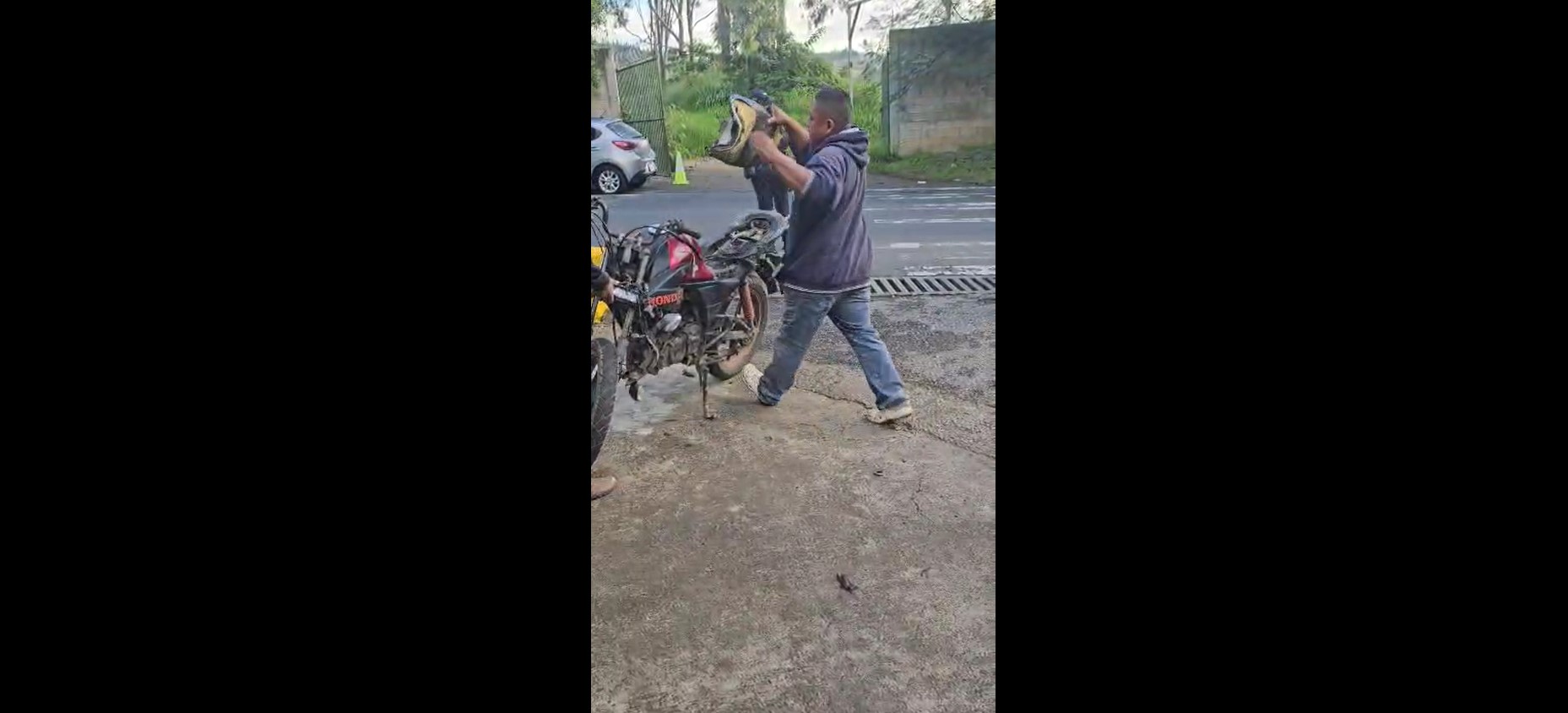 El motorista arranca piezas de su motocicleta frente a agentes, luego de ser multado por no portar licencia, durante un operativo en Villa Nueva. (Foto Prensa Libre: Captura de pantalla)