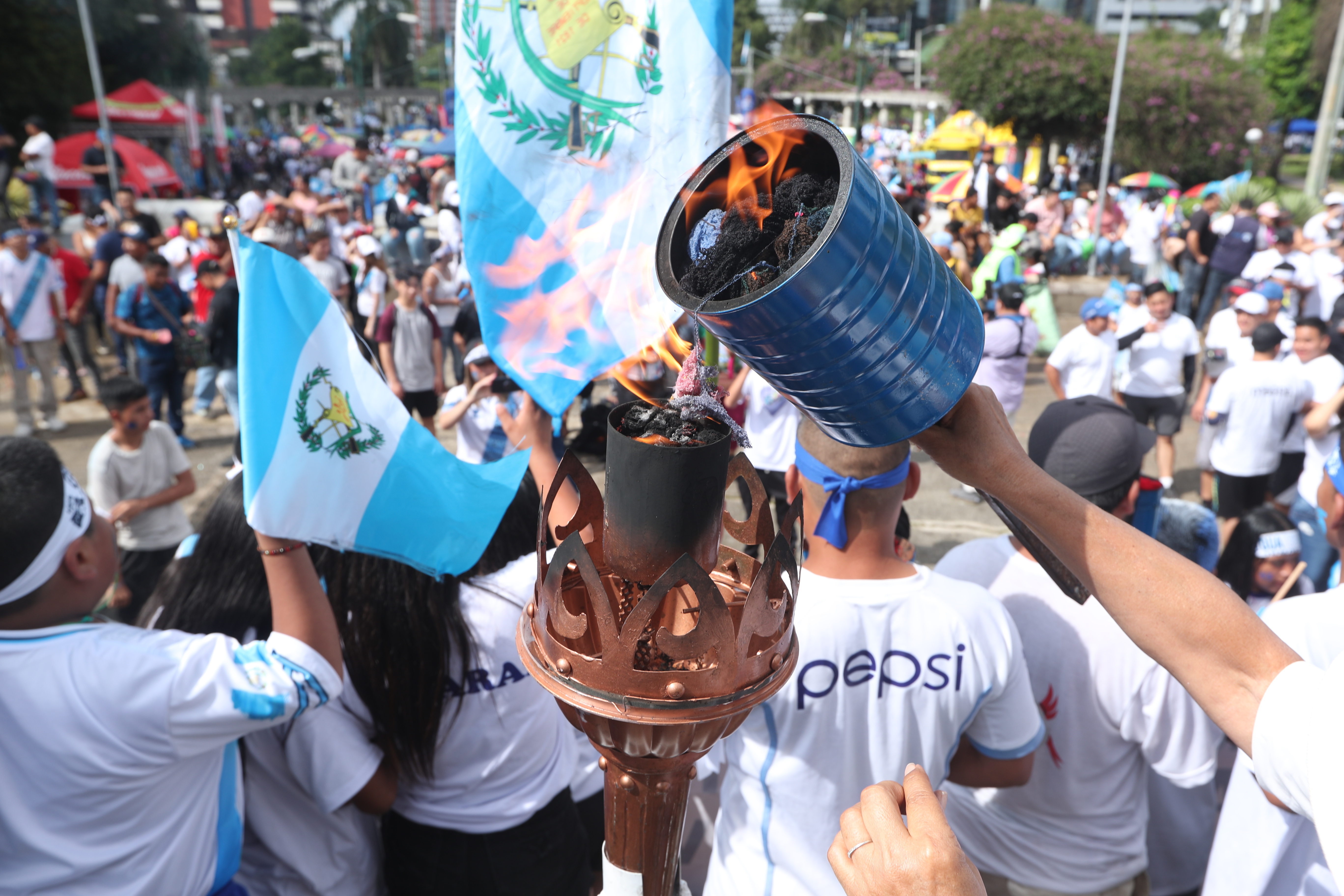 Persona sostiene una antorcha encendida en el Obelisco durante las festividades de independencia de Guatemala.
