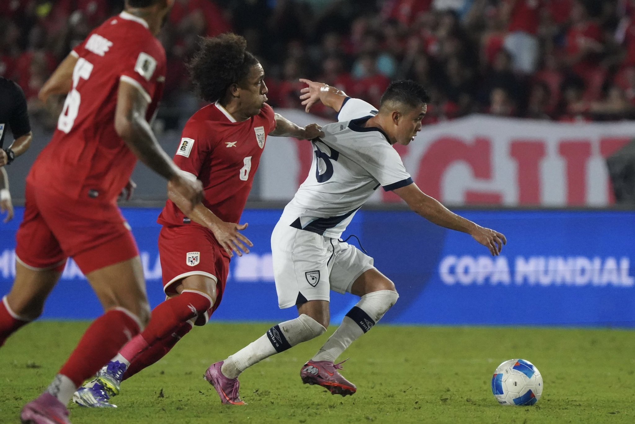 Óscar Santis de Guatemala (18) lleva el esférico y es jalado de la camiseta por el mediocampista de Panamá Adalberto Carrasquilla (8). Foto Prensa Libre: Fedefut.