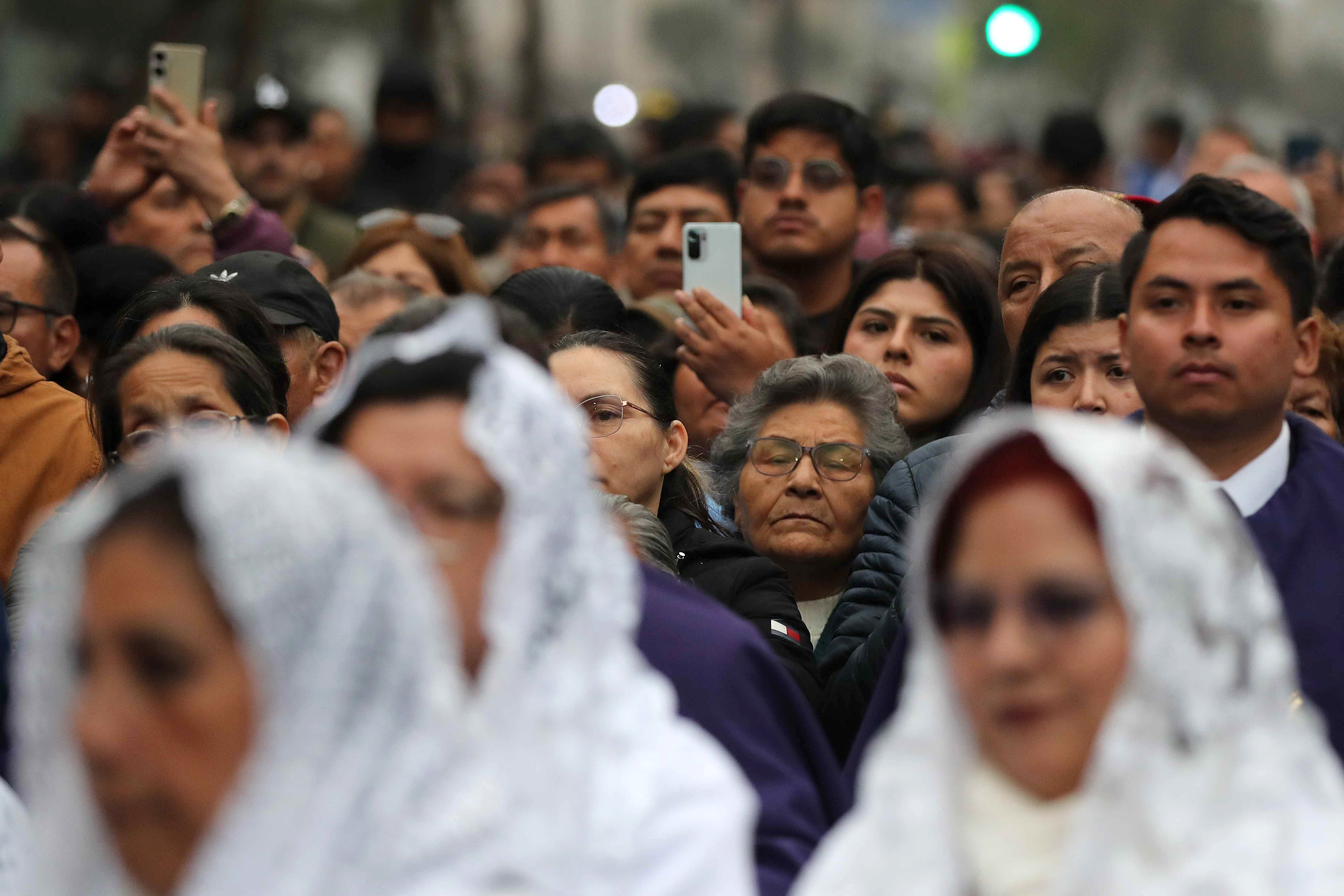 AME2682. LIMA (PERÚ), 28/10/2025.- Devotos esperan el paso de la imagen del Señor de los Milagros este martes, en Lima (Perú). El Señor de los Milagros, la imagen religiosa más venerada por los peruanos, realiza su principal procesión en una caminata de fervor religioso que congrega a miles de personas. EFE/Paolo Aguilar