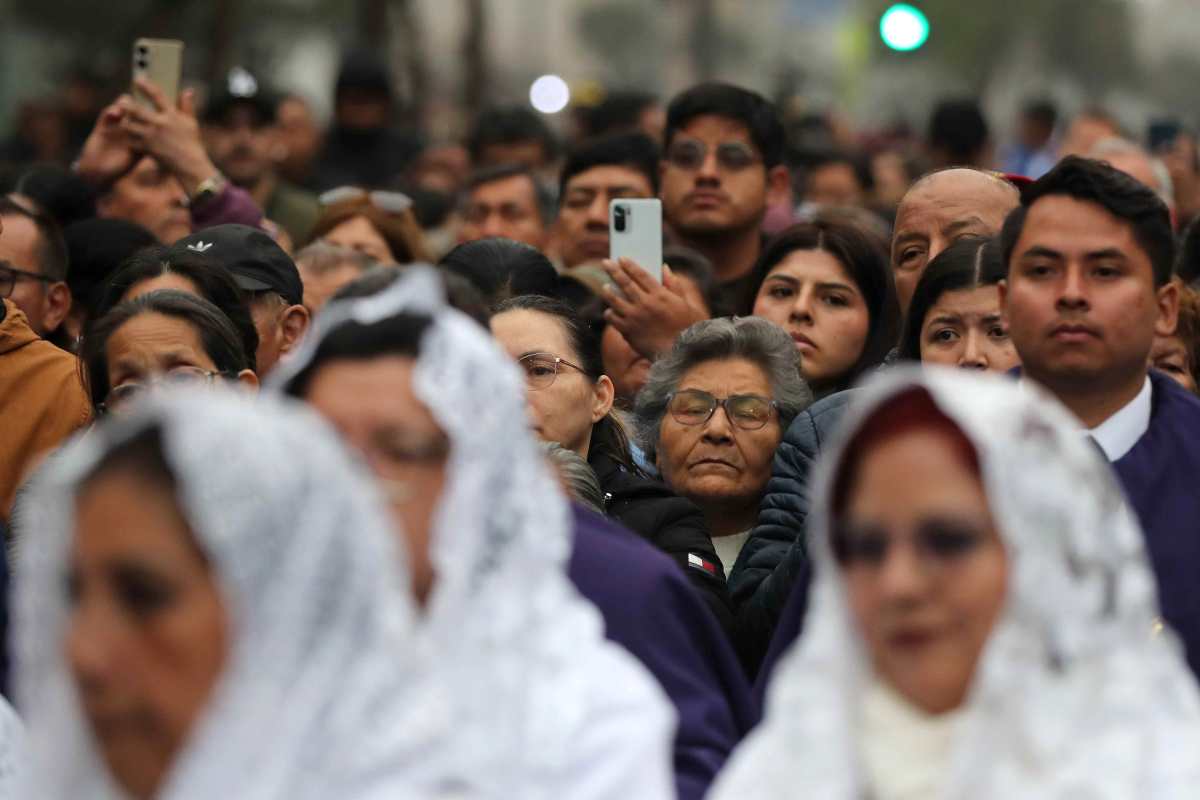 AME2682. LIMA (PERÚ), 28/10/2025.- Devotos esperan el paso de la imagen del Señor de los Milagros este martes, en Lima (Perú). El Señor de los Milagros, la imagen religiosa más venerada por los peruanos, realiza su principal procesión en una caminata de fervor religioso que congrega a miles de personas. EFE/Paolo Aguilar