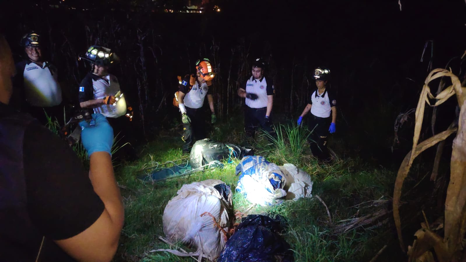 Socorristas extraen los cuerpos localizados entre la maleza, en el kilómetro 21 de la ruta al Atlántico, Palencia.  (Foto Prensa Libre: Bomberos Voluntarios)