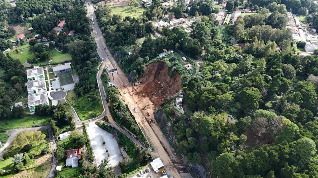 Imagen aérea que muestra maquinaria y personal trabajando directamente sobre el punto del derrumbe en el km 24 de la Carretera a El Salvador.