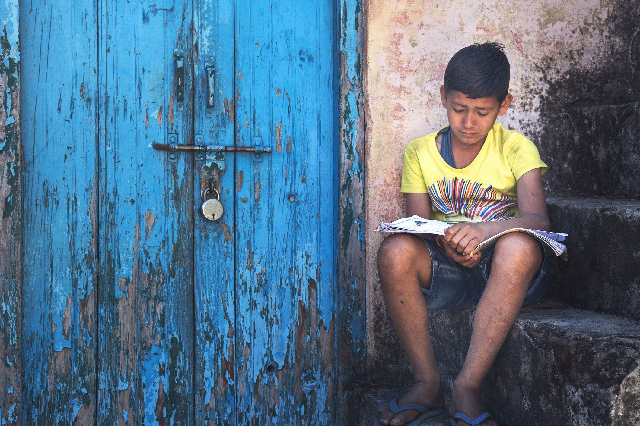 Niño leyendo con cara de tristeza.