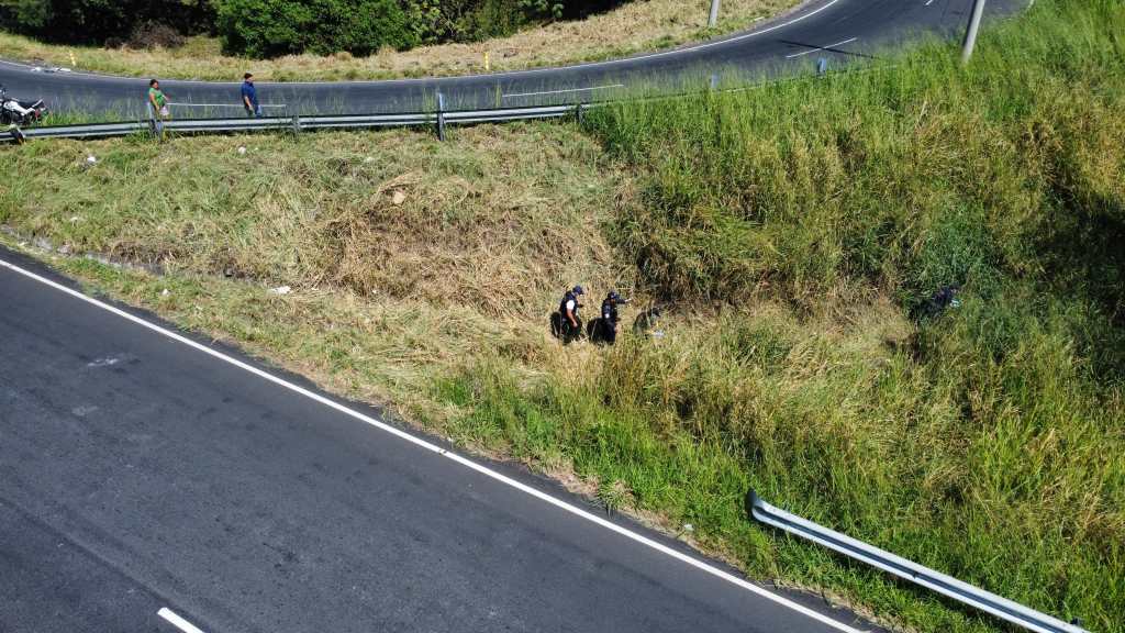 Agentes de la PNC se adentran en una zona de maleza, donde fue localizado un cuerpo en descomposición.