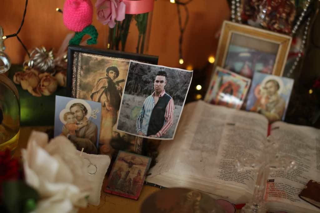 Biblia abierta y fotografías de Zoel Cruz forman un pequeño altar en su memoria durante un homenaje en Guatemala.