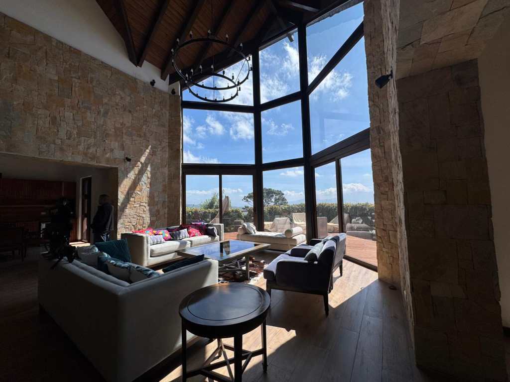 Cocina y área social con ventanales y vista al bosque.