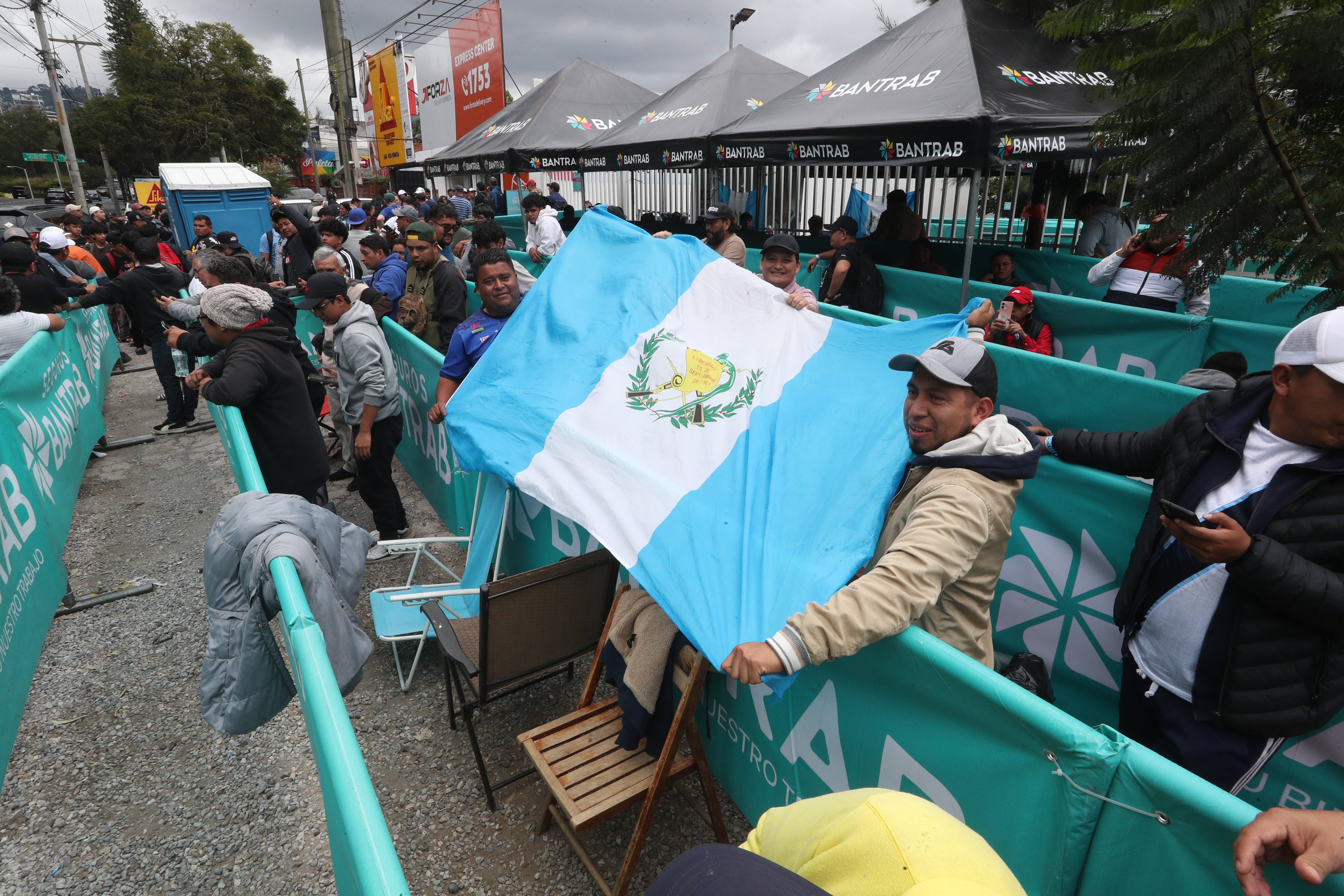 Aficionados con una bandera de Guatemala hacen fila, a la espera del inicio de la venta de boletos mañana para los partidos ante Surinam y Panamá. (Foto Prensa Libre: Esbin Garcia)