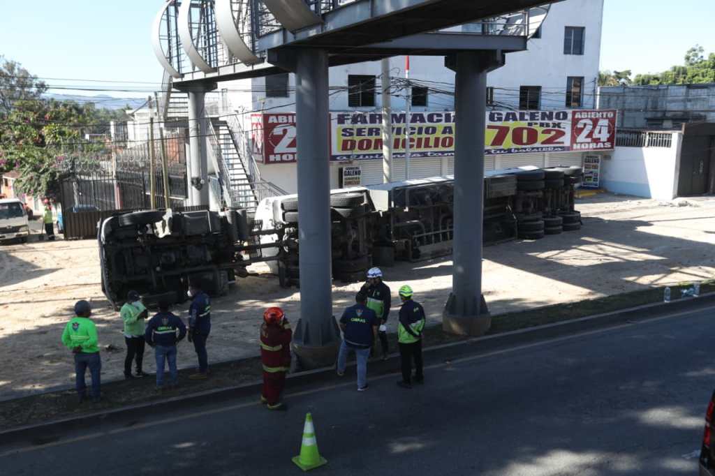 Trabajadores municipales vistos desde una pasarela mientras atienden el área del accidente.