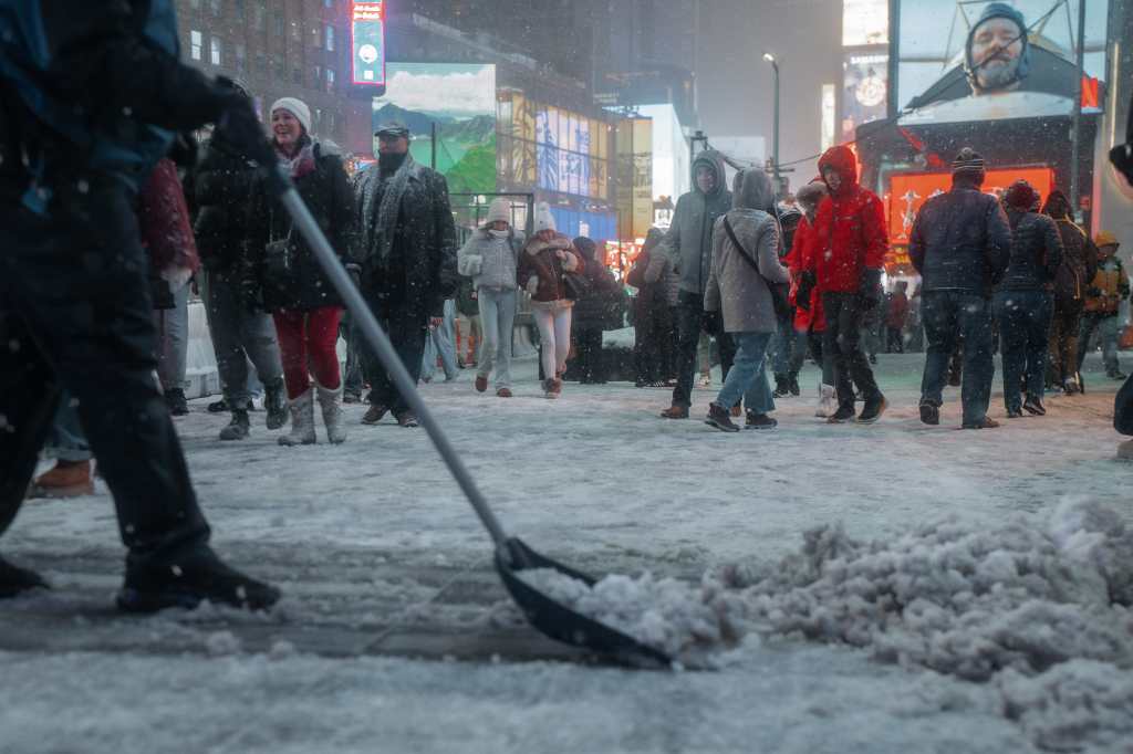 NEW YORK (United States), 27/12/2025.- A person shovels snow in Times Square during a winter storm in New York, New York, USA, 26 December 2025. A weather emergency was declared as up to 11 inches of snow was forecast, and hundreds of flights were grounded at New York-area airports. (tormenta, Nueva York) EFE/EPA/OLGA FEDOROVA
