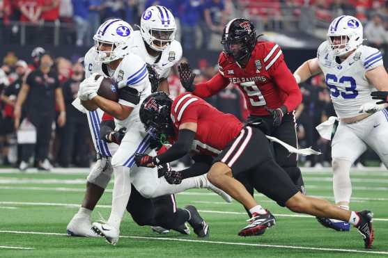 ARLINGTON, TEXAS - DECEMBER 06: LJ Martin #4 of the BYU Cougars is hit during his touchdown run by Brenden Jordan #7 of the Texas Tech Red Raiders during the first quarter in the 2025 Edward Jones Big 12 Championship at AT&T Stadium on December 06, 2025 in Arlington, Texas.   Stacy Revere/Getty Images/AFP (Photo by Stacy Revere / GETTY IMAGES NORTH AMERICA / Getty Images via AFP)