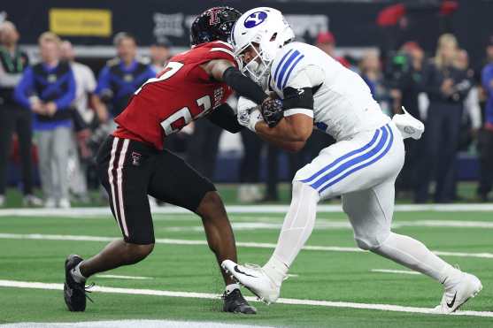 ARLINGTON, TEXAS - DECEMBER 06: LJ Martin #4 of the BYU Cougars scores a touchdown as he is hit by Amier Boyd #27 of the Texas Tech Red Raiders during the first quarter in the 2025 Edward Jones Big 12 Championship at AT&T Stadium on December 06, 2025 in Arlington, Texas.   Stacy Revere/Getty Images/AFP (Photo by Stacy Revere / GETTY IMAGES NORTH AMERICA / Getty Images via AFP)