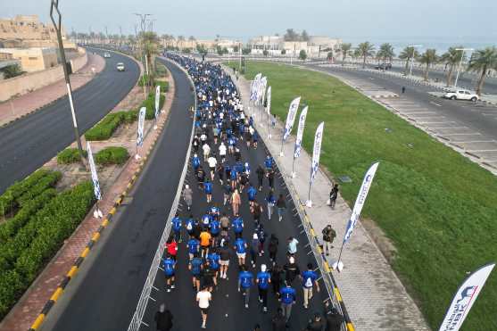 An aerial photograph shows runners participating in a marathon in Kuwait City on December 13, 2025. (Photo by YASSER AL-ZAYYAT / AFP)