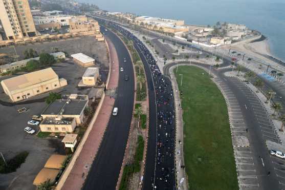 An aerial photograph shows runners participating in a marathon in Kuwait City on December 13, 2025. (Photo by YASSER AL-ZAYYAT / AFP)