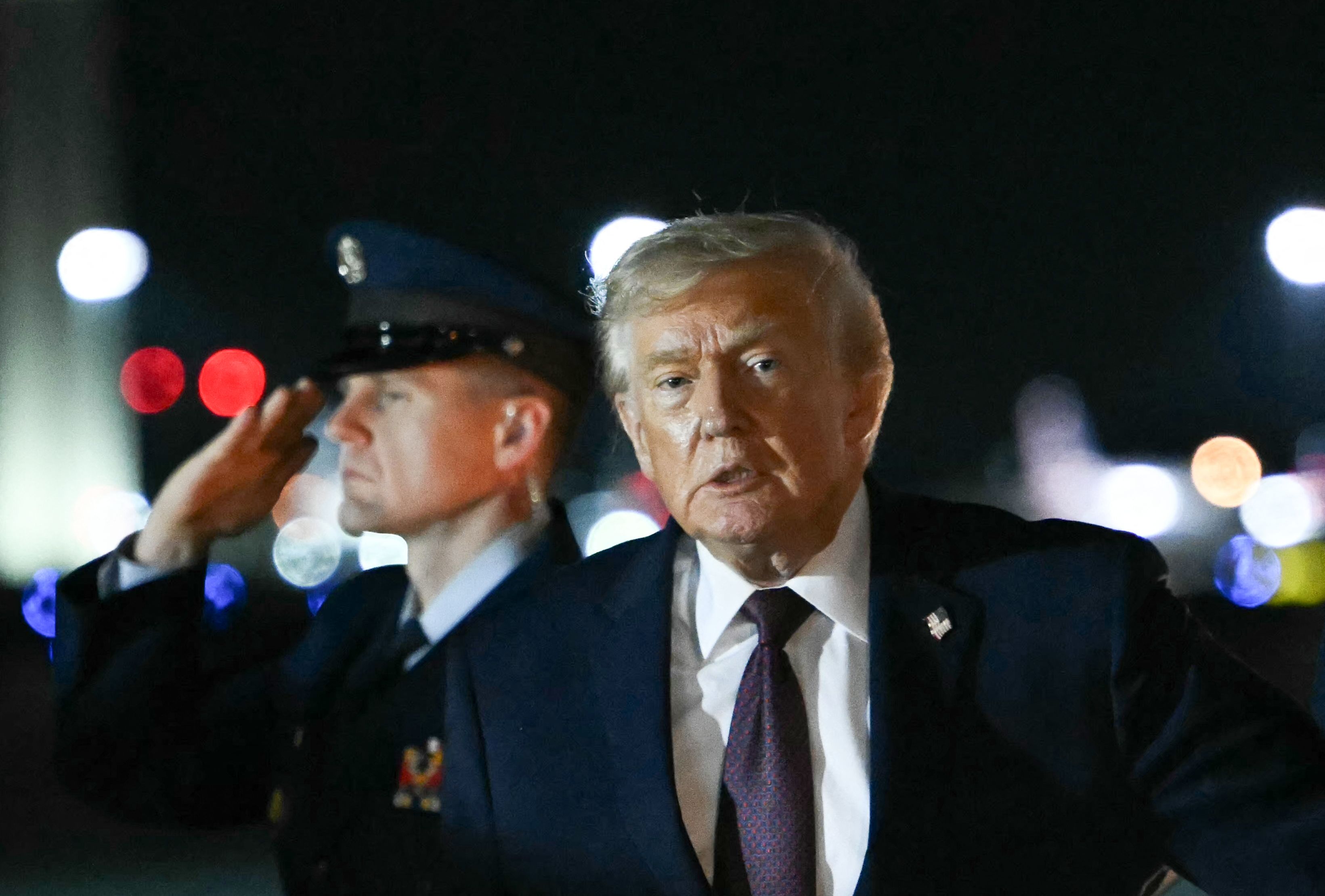 US President Donald Trump gestures after stepping off AIr Force One at Palm Beach International Airport in Palm Beach, Floida on December 19, 2025. President Trump is in Florida to spend the holidays at his Mar-a-Lago estate. (Photo by ANDREW CABALLERO-REYNOLDS / AFP)