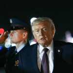 US President Donald Trump gestures after stepping off AIr Force One at Palm Beach International Airport in Palm Beach, Floida on December 19, 2025. President Trump is in Florida to spend the holidays at his Mar-a-Lago estate. (Photo by ANDREW CABALLERO-REYNOLDS / AFP)