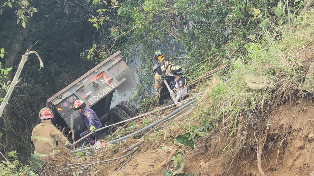 Socorristas laboran para sofocar el fuego en un tráiler accidentado en el km 32 de la ruta Interamericana. (Foto Prensa Libre: Bomberos Voluntarios)
