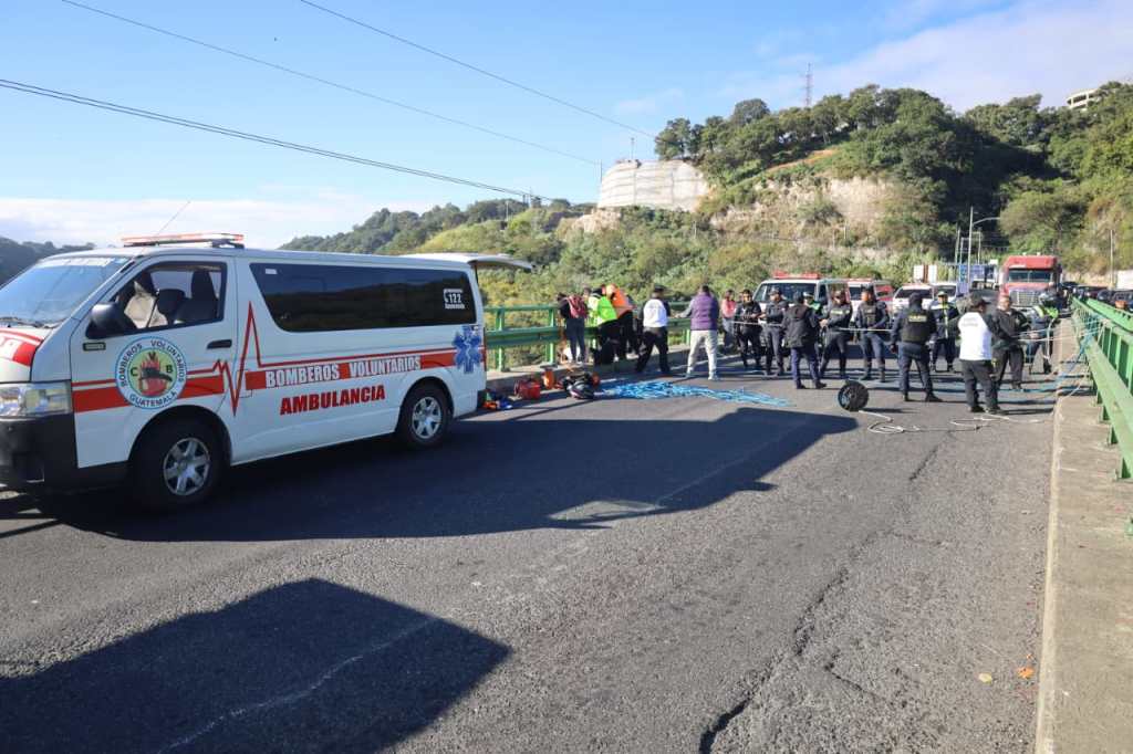Bomberos cruzan la mitad del puente Charcas sosteniendo la soga durante un operativo de rescate y acompañamiento psicológico a una persona en Mixco.