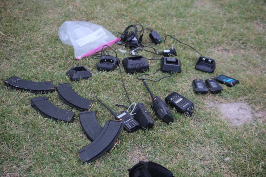 Radios portátiles incautados y colocados en el suelo para documentación del MP