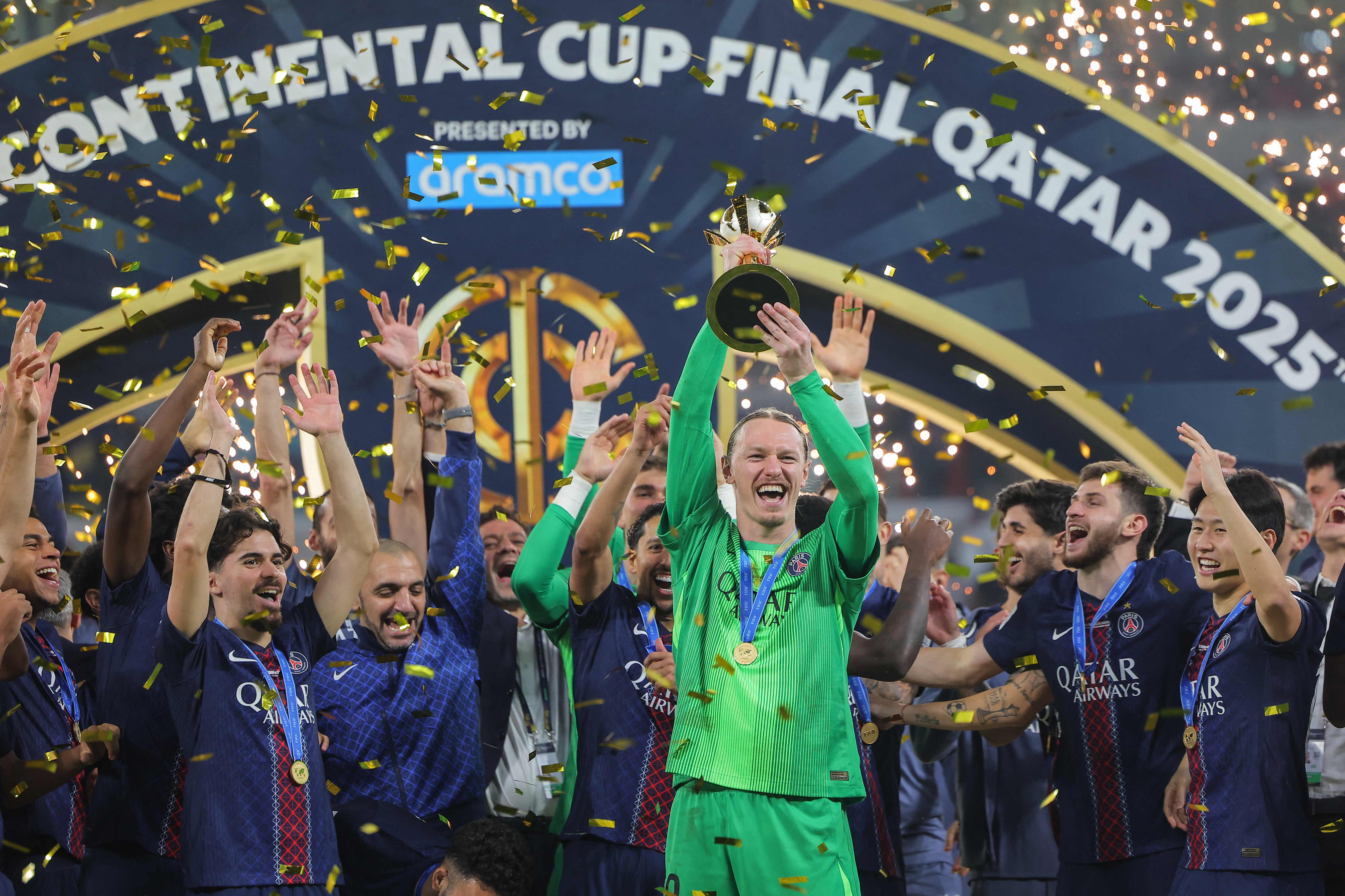 PSG's players celebrate on the podium after winning the 2025 FIFA Intercontinental Cup final football match between Paris Saint-Germain (PSG) and CR Flamengo at the Ahmad bin Ali Stadium in Al-Rayyan on the outskirts of Doha on December 17, 2025. (Photo by Karim JAAFAR / AFP)